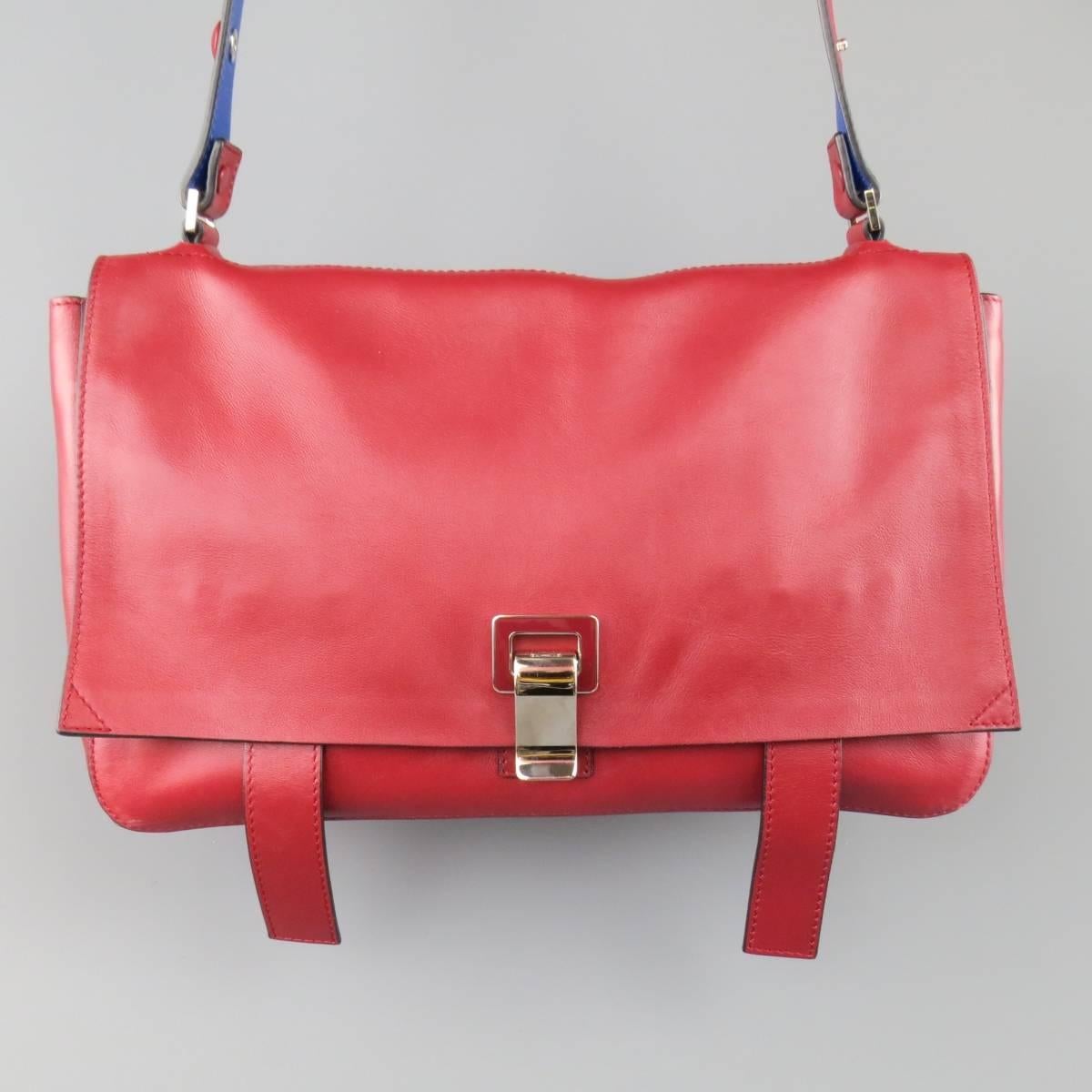 Rare PROENZA SHCOULER shoulder bag in a smooth red leather featuring a flap with enamel and silver tone metal clasp and hanging straps, adjustable shoulder strap, side snaps, and  blue leather interior. Minor Wear. Includes Dust Bag.
 
Good