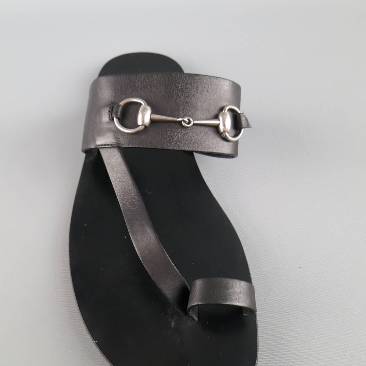Classic GUCCI sandals in smooth black leather featuring a thick strap with silver tone horsebit and toe loop. Damage on horsebit strap shown in detail shot. As-Is. Made in Italy.
 
Good Pre-Owned Condition.
Marked: UK 10
 
Outsole: 11.5 x 4.5 in.
