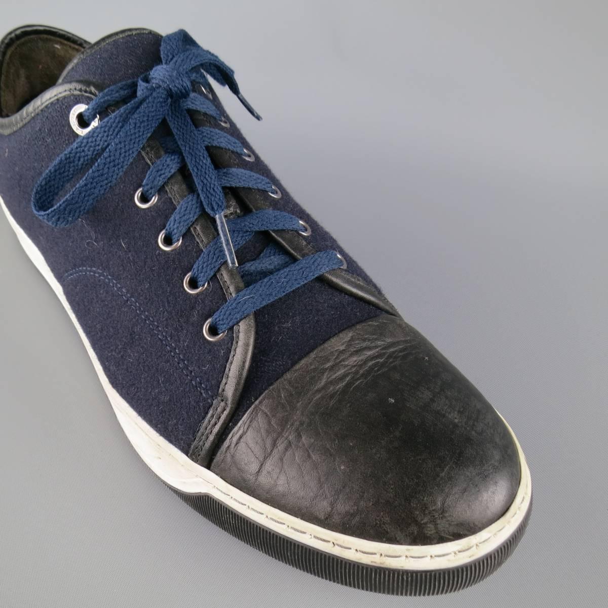LANVIN sneakers come in a deep navy blue wool felt and feature black leather piping, an embossed black leather cap toe, and black and white rubber sole. Made in Portugal.
 
Good Pre-Owned Condition.
Marked: UK 11
 
Outsole: 12.5 x 4.5 in.
