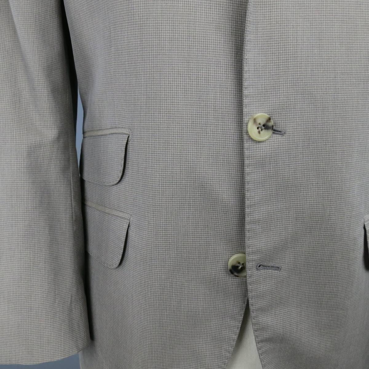 BRUNELLO CUCINELLI Sport Coat consists of cotton material in a taupe color tone. Designed in a notch lapel collar, 3-button front and houndstooth pattern. Detailed with top pocket square and bottom flap pockets. 4-button cuffs and double back vent.