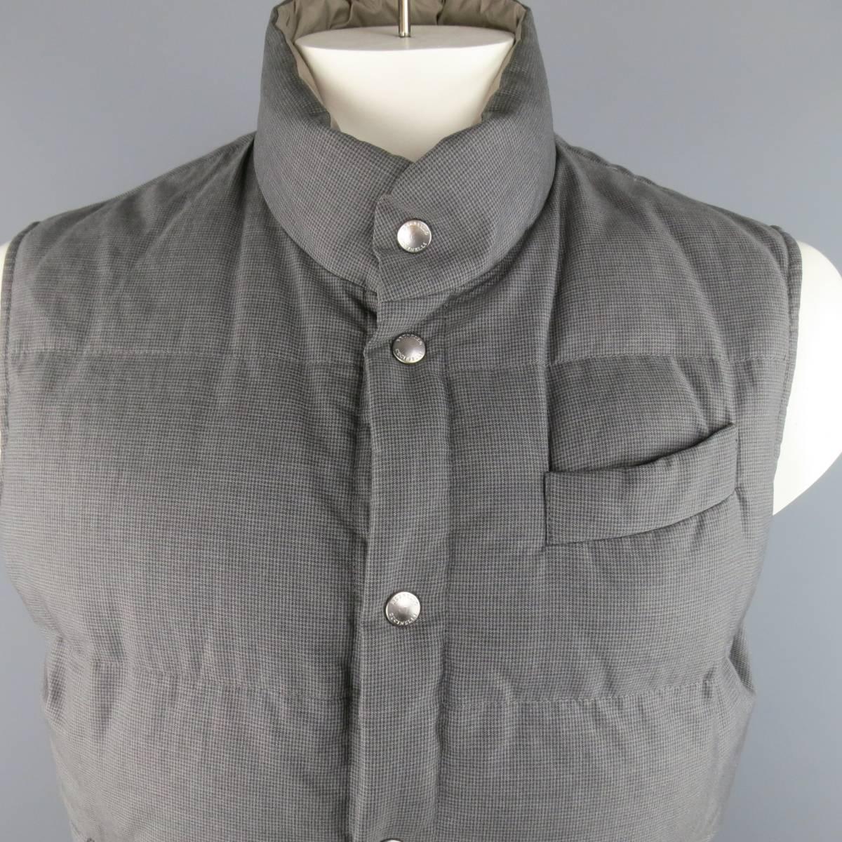 BRUNELLO CUCINELLI Vest consists of cotton material in a grey color tone. Designed in a reversible style, solid taupe and houndstooth pattern. Top pocket square with bottom side pockets. Silver button detail and elastic waist hem. Made in Italy.
