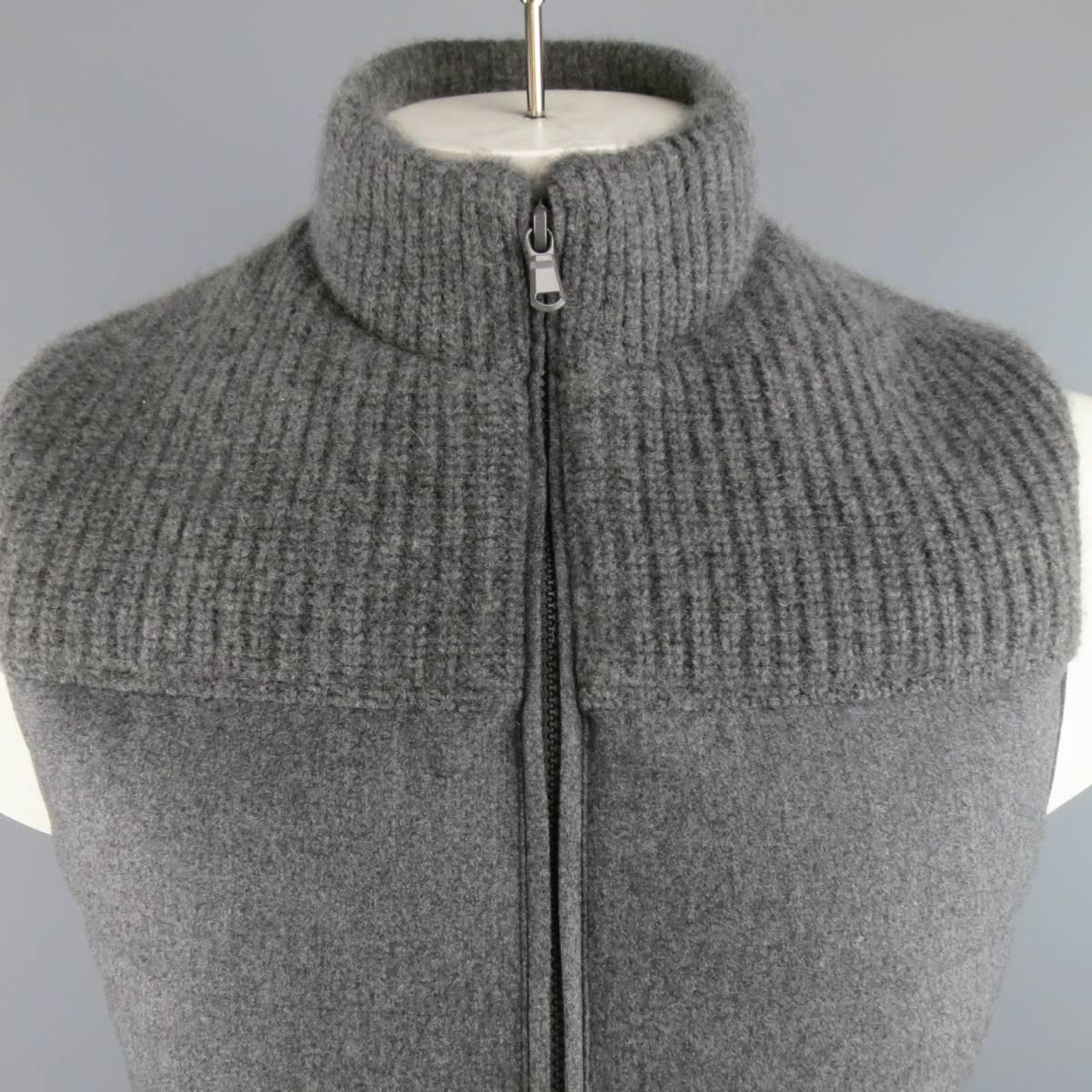 BRAND NEW BRUNELLO CUCINELLI Vest consists of wool/silk and cashmere material in a grey color tone. Designed in a high collar, zip-up front with top knit pattern. Quilted stitching toward bottom section and side pockets. New with tags.
Comes with