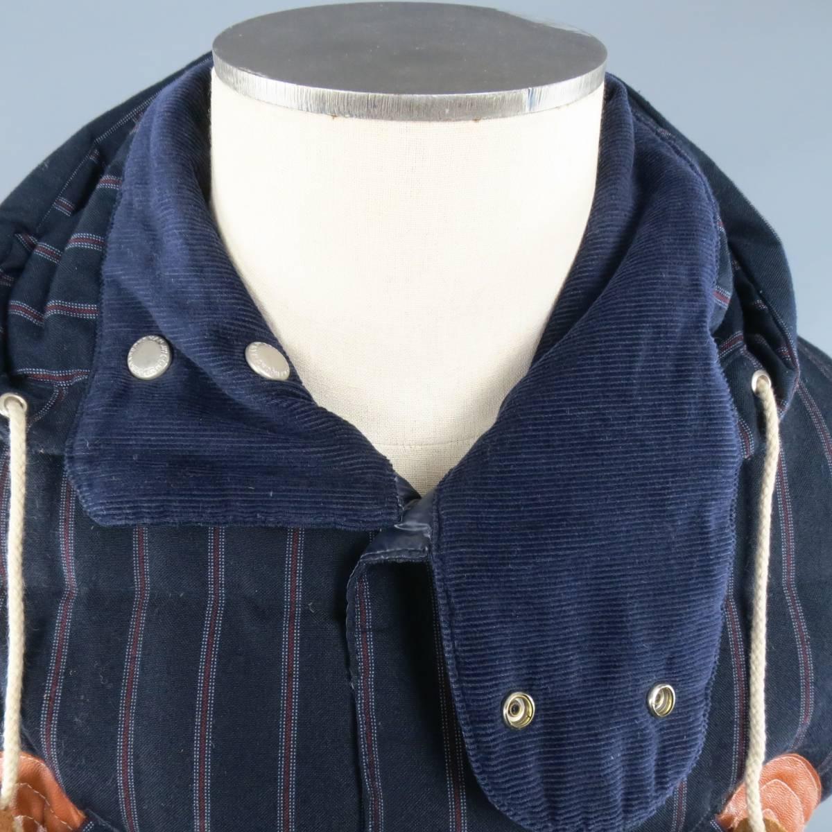 JUNYA WATANABE quilted down vest in a navy and burgundy striped wool mohair fabric featuring a high collar hood with corduroy liner, snap pockets, tan leather details, and nylon liner. Wear throughout. Made in Japan.
 
Good Pre-Owned