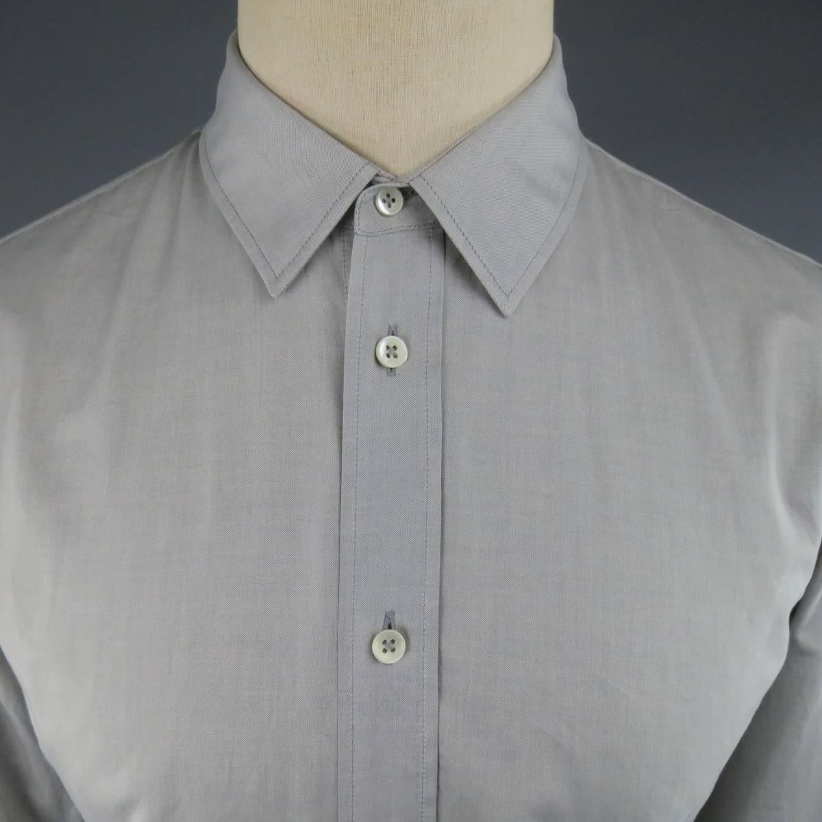 Classic MAISON MARTIN MARGIELA button up oxford in a silver gray with a pointed collar and signature back stitches. Made in Romania.
 
Excellent Pre-Owned Condition.
Marked: IT 48
 
Measurements:
 
Shoulder: 17 in.
Chest: 40 in.
Sleeve: 26