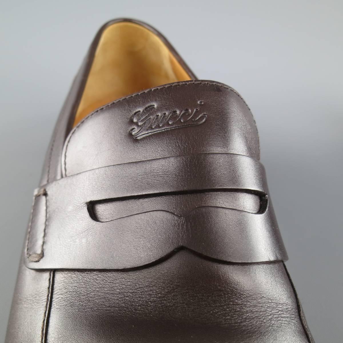 GUCCI penny loafers in a rich chocolate brown leather with a pointed apron toe and cursive logo embossed tongue. Made in Italy.
 
Excellent Pre-Owned Condition.
Marked: 10.5 D
 
Outsole: 12.5 x 4 in.