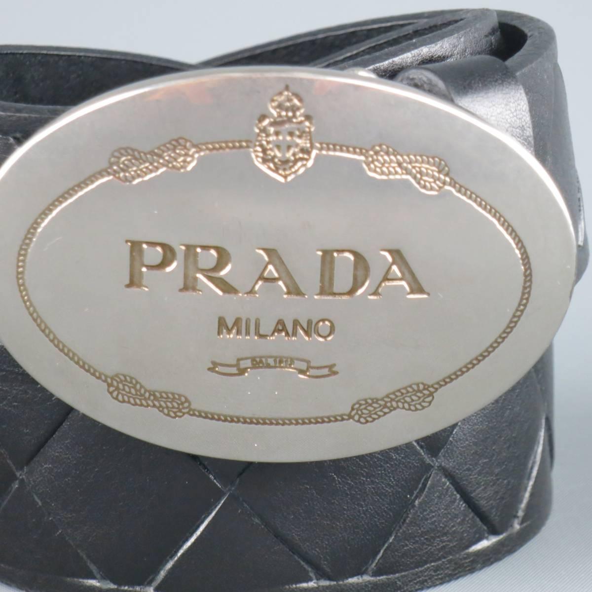 PRADA belt features a black smooth woven leather strap and silver tone engraved logo oval shaped buckle. Made in Italy.
 
Excellent Pre-Owned Condition.
Marked: 8
 
Length: 48 in.
Width: 1.5 in.
Fits: 40-44 in.
Buckle: 3 x 2 in.
