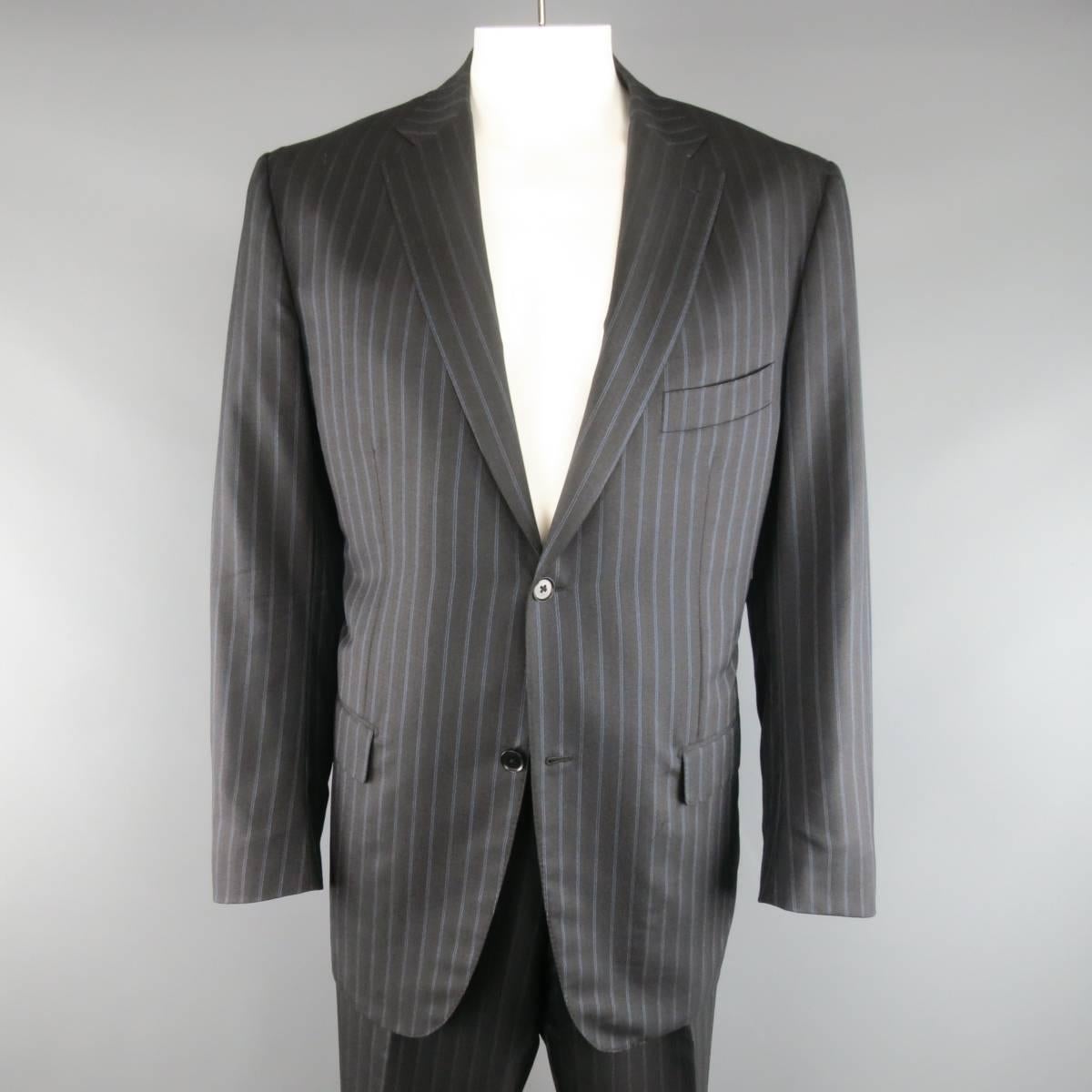 ISAIA suit comes in a herringbone textured charcoal wool silk blend with blue pin stripe pattern and includes a two button sport coat with notch lapel, flap pockets, and functional button cuffs with matching flat front dress pants. Made in Italy.
