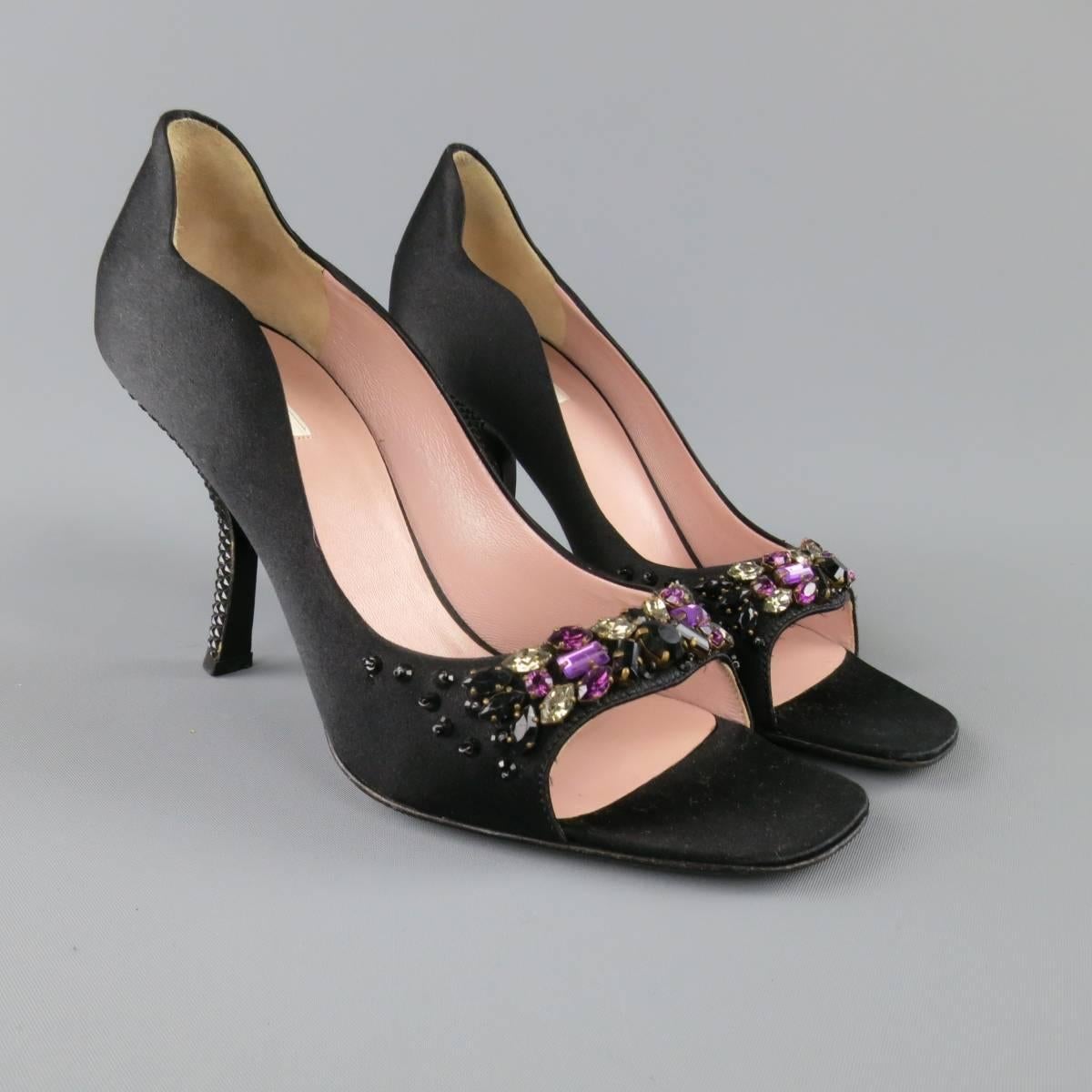 These fabulous PRADA pumps come in a black silk satin and feature an open pepp toe with purple black and white crystal gem embellishments, curvy topline and underslung, curved heel with pyramid studded texture. Minor imperfections in silk on heel.