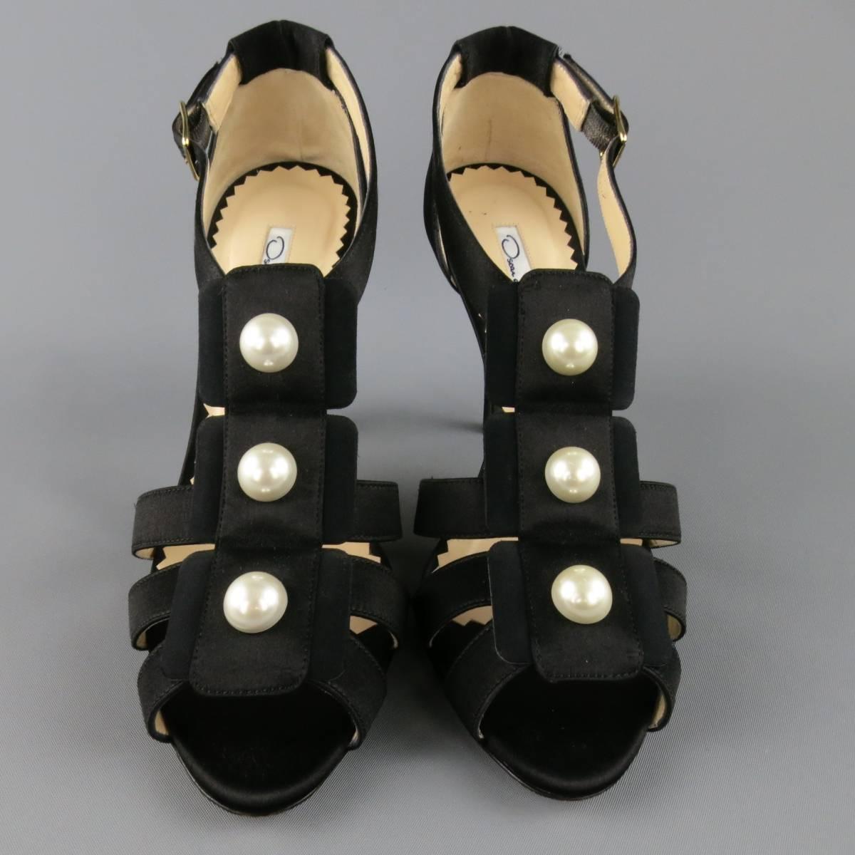These gorgeous OSCAR DE LA RENTA sandals come in black silk satin and feature a gladiator style strap construction with oversized faux pearl details and covered stiletto heels. Made in Italy.
 
Excellent Pre-Owned Condition. Retails at