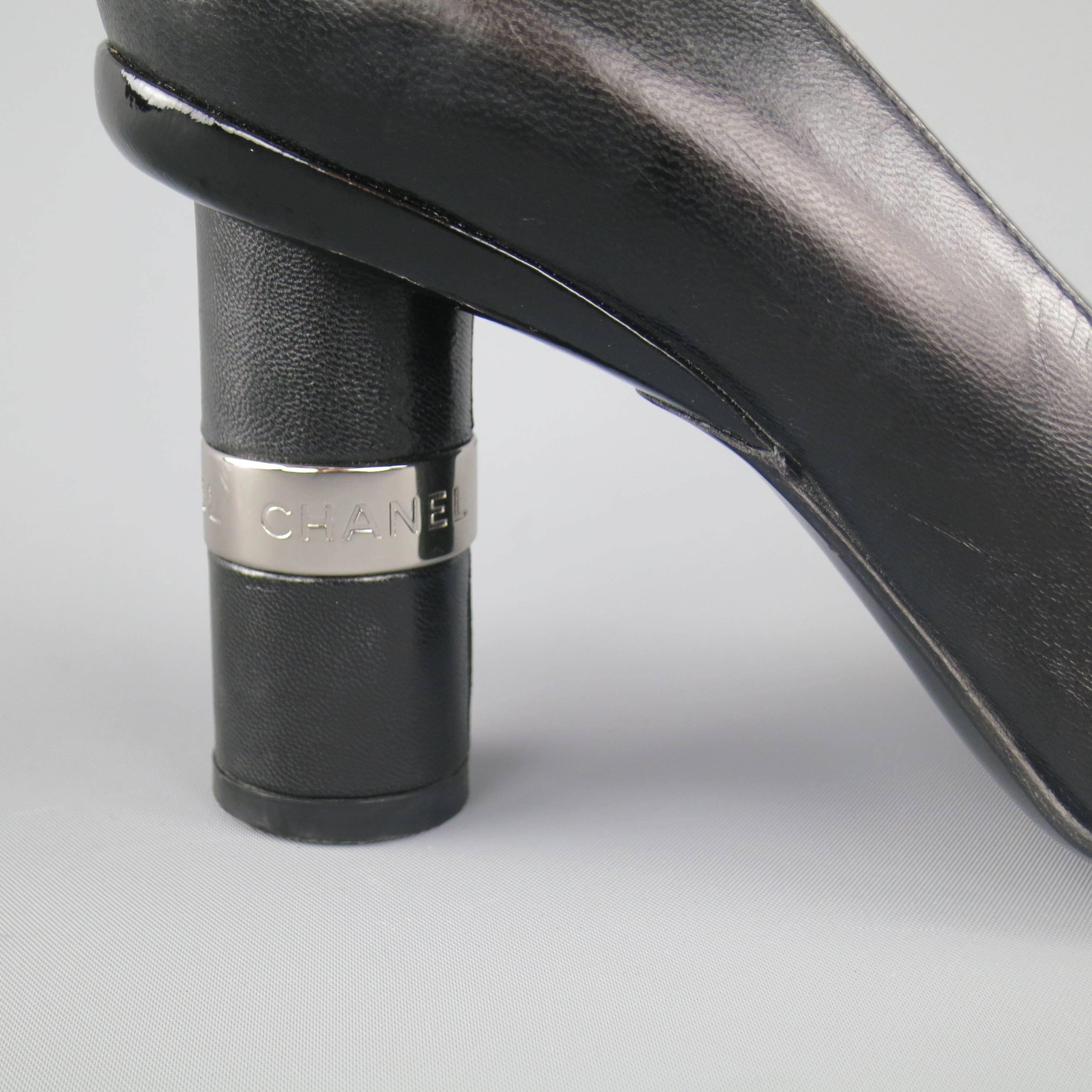 These fabulous vintage CHANEL pumps come in smooth black leather and feature a square toe with patent stripes, and a thick, cylindrical covered heel with silver tone logo engraved metal detail.  Made in Italy.
 
Excellent Pre-Owned