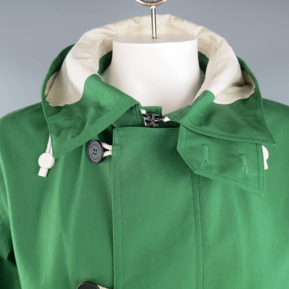 BURBERRY PRORSUM jacket in a Kelly green coated cotton featuring a zip front with button over placket, patch flap pockets, high neck drawstring hood, and adjustable tab cuff sleeves. Made in Italy.
 
Good Pre-Owned Condition.
Marked: IT 54
