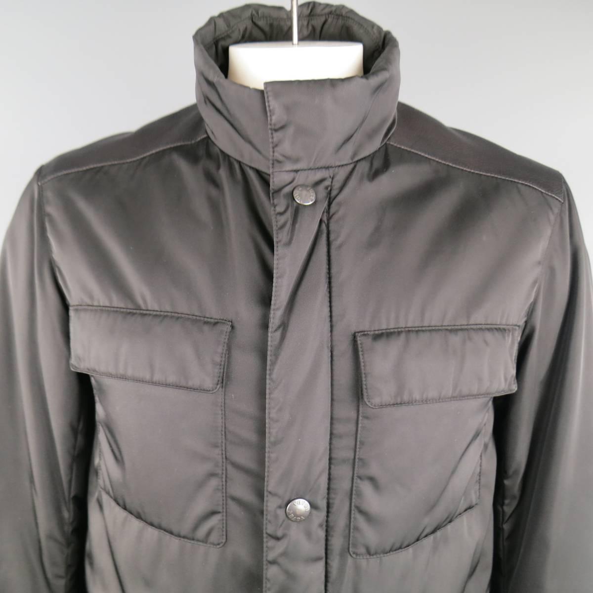 PRADA military inspired coat in a black polyester twill featuring a high neck with optional hood, leather shoulder panels, zip front with snap placket, and four patch flap pockets. Made in Italy.
 
Good Pre-Owned Condition.
Marked: (no tag)
