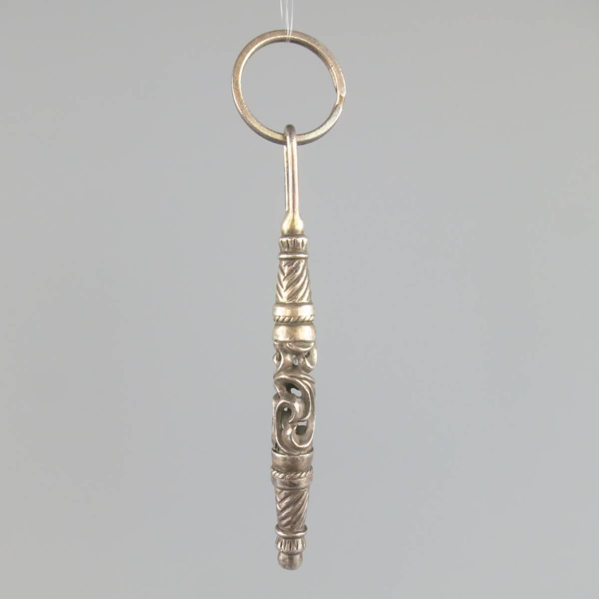CHROME HEARTS keychain in sterling silver featuring a long engraved wand on a hoop. Tarnishing throughout.
 
Good Pre-Owned Condition.
 
Wand:11 cm x 1 cm


Web ID: 81361 