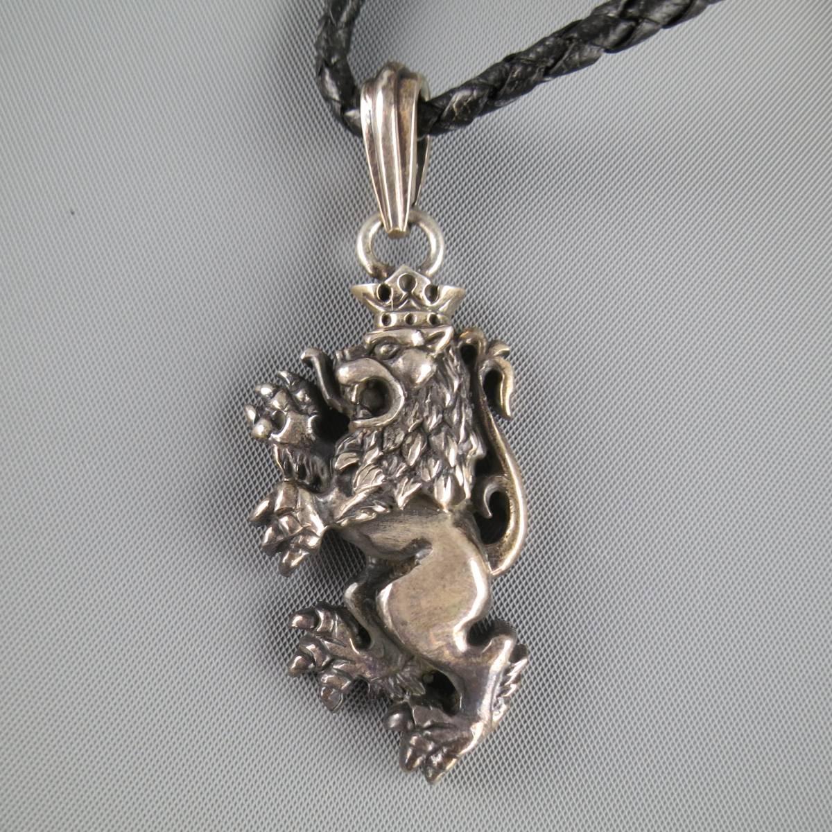 Royal Underground necklace features a sterling silver engraved lion charm on a black braided leather rope. Wear throughout leather. With Box.
 
Excellent Pre-Owned Condition.
 
Necklace: 25 in.
Charm: 5 x 3 cm.


Web ID: 81360 
