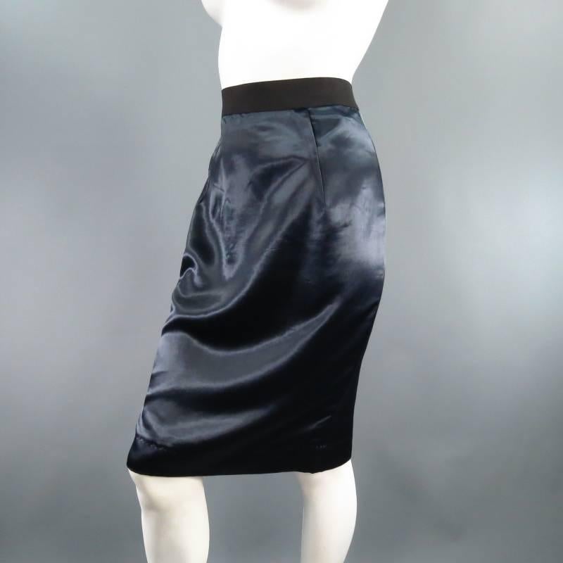 Lovely navy pencil skirt by LANVIN. A classic staple redesigned, this piece comes in gorgeous semi structured silk/Cupro satin and features folded exterior darts, thick black elastic waist band and exposed back zip slit. Circa 2006. Made in France.
