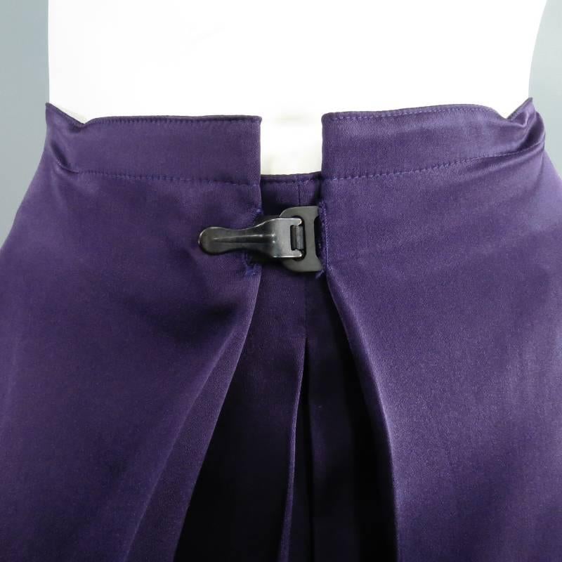 Fabulous A-line skirt LANVIN. This piece comes in a gorgeous, flowing eggplant silk satin and features symmetrical  layered front pleats that fold inward and fasten with a charcoal clasp. Circa 2007. Made in France.
 
Excellent Pre-Owned