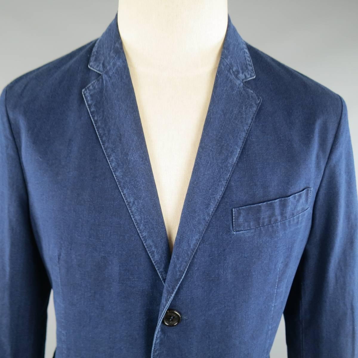 PRADA sport coat in an indigo navy blue washed denim look cotton featuring a notch lapel, two button closure, patch pockets, and functional button cuffs. Made in Hungary. 

Retails at $2100.00.
 
Excellent Pre-Owned Condition.
Marked: IT 50
