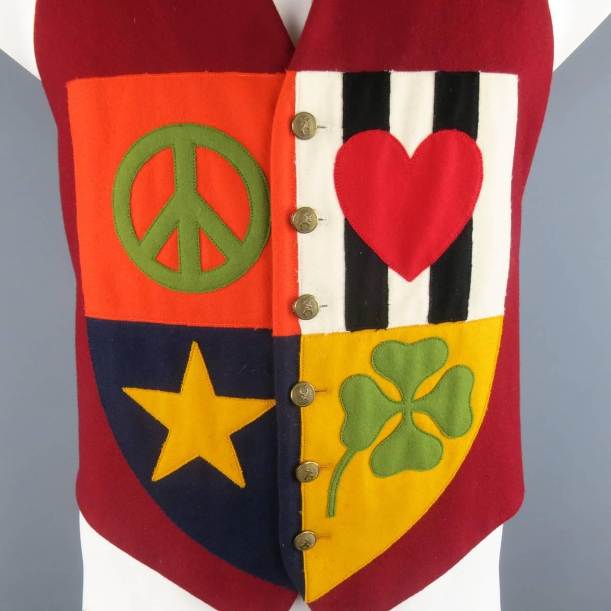 Vintage MOSCHINO Cheap and Chic v neck vest comes in a rich burgundy wool and features an orange, navy, gold, and striped, patchwork crest with peace, heart, star, and clover symbols, and a black and white striped satin back panel. Wear throughout