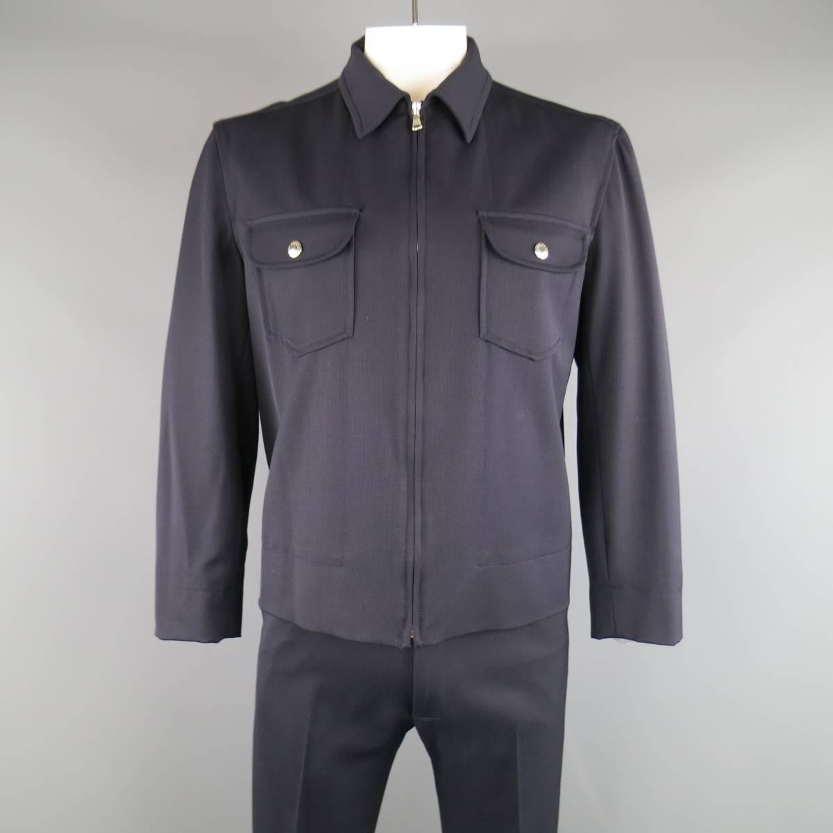 DOLCE & GABBANA two piece workwear inspired outfit comes in a navy blue wool blend twill and includes a classic collared jacket with snap patch pockets and back tabs with matching flat front pants. Made in Italy.
 
Excellent Pre-Owned