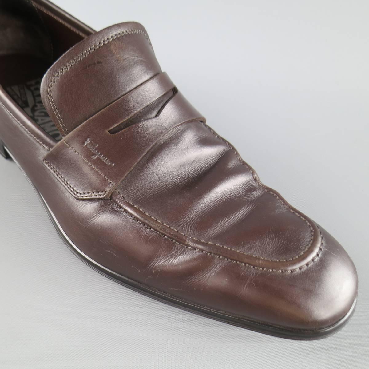 SALVATORE FERRAGAMO classic penny loafers come in a rich chocolate brown leather and feature an apron toe and cutout strap. Wear on toe. With box. Made in Italy.
 
Good Pre-Owned Condition.
Marked: 7.5 E
 
Outsole: 11.5 x 3.75 in.


Web ID: 82945 