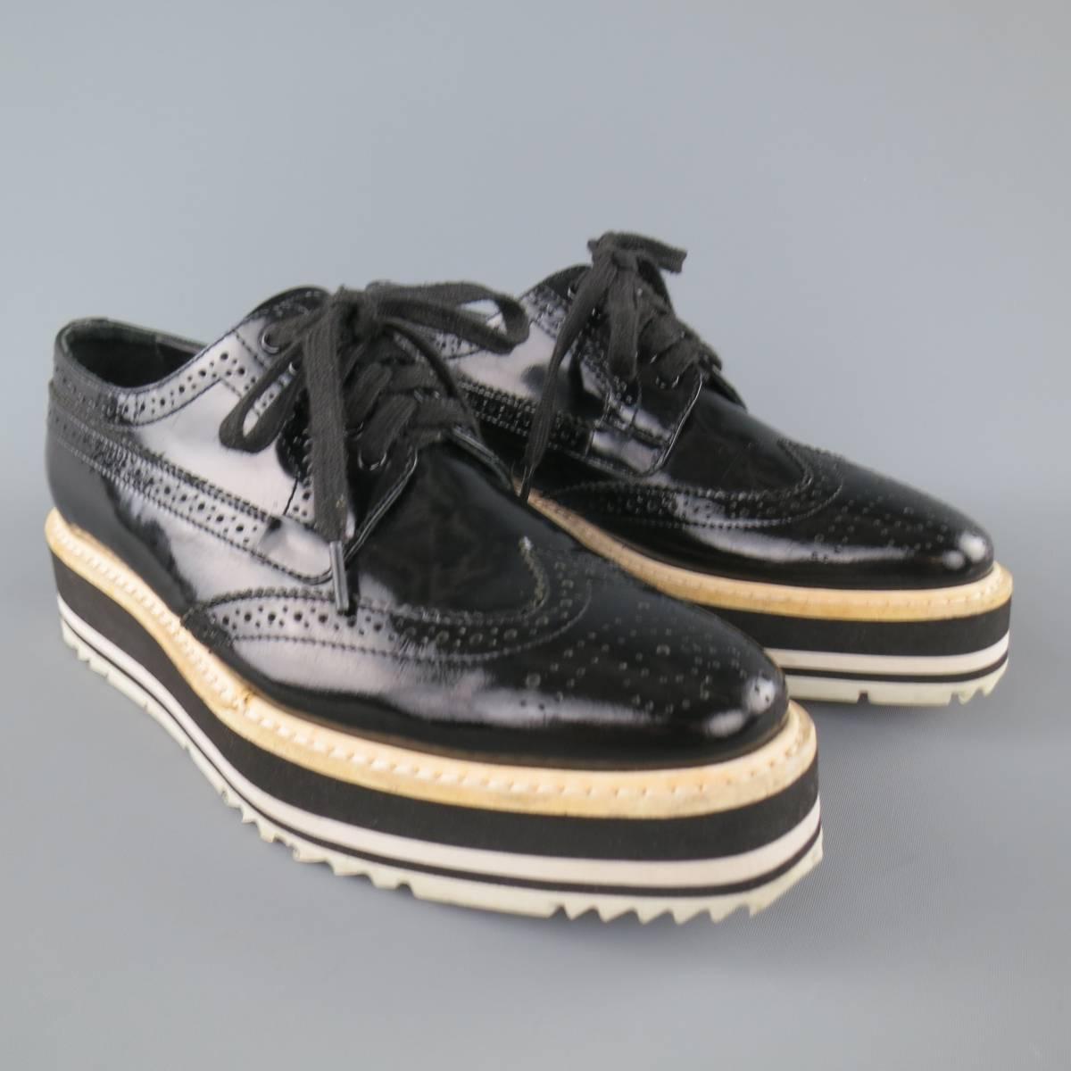 PRADA brogues come in a glossy patent leather and feature a wingtip, perforated details throughout, and black and white striped platform sole. Made in Italy.
 
Good Pre-Owned Condition.
Marked: 36
 
Platform: 1.5 in.


Web ID: 83054 