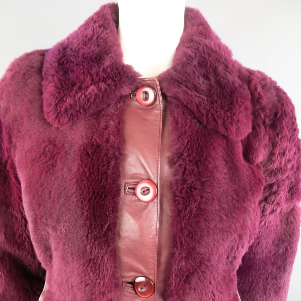 D&G by DOLCE & GABBANA bomber jacket comes in a dark magenta purple leather with matching colored rabbit fur panels and features a large pointed collar, button up closure, and ribbed waistband. Wear and imperfections throughout fur. As-Is. Priced