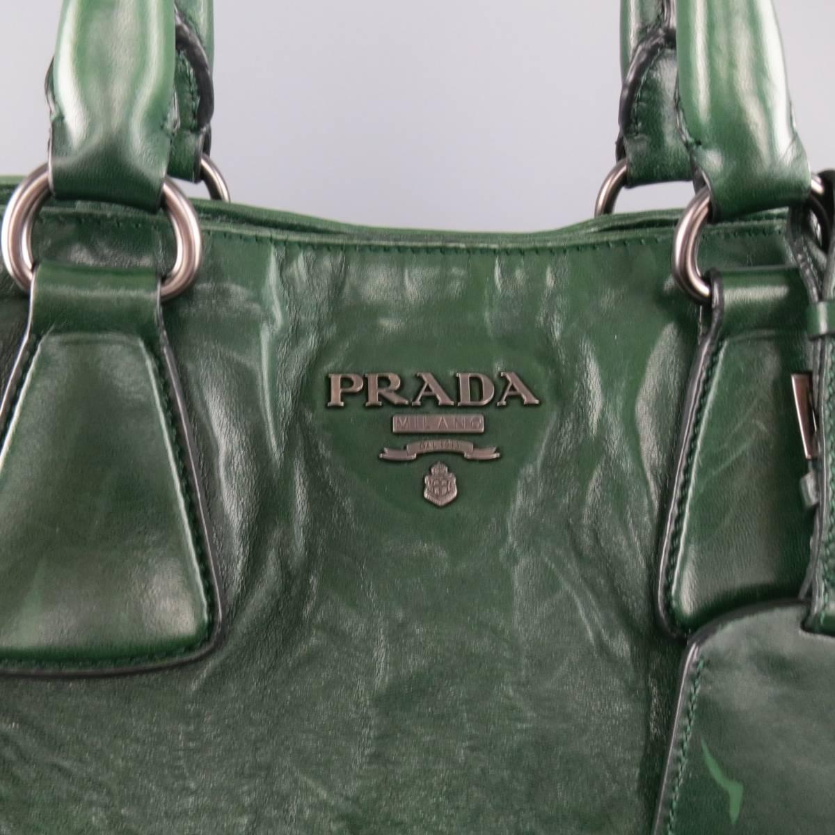 Unique PRADA tote bag comes in a green wrinkle textured leather and featured a dark silver tone metal logo at front, double covered top handles, luggage tag, top snap closure, and detachable shoulder strap. Wear throughout. As-Is. Made in italy. AD