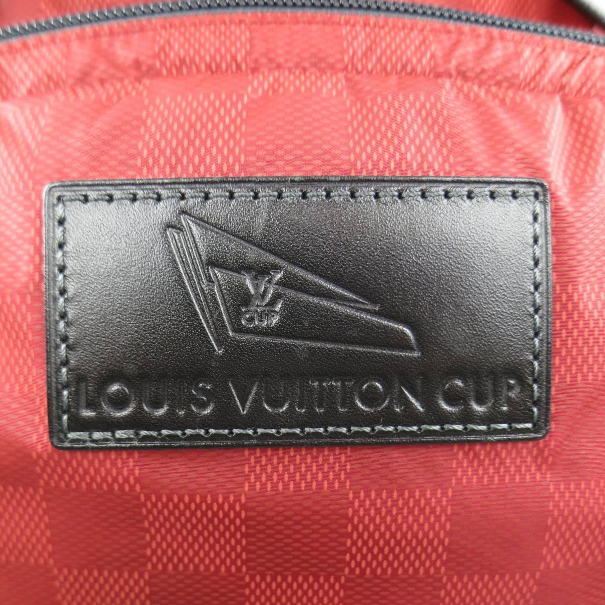 LOUIS VUITTON Cup 2012 backpack comes in a brick red Damier print nylon and features a frontal zip pocket with black embossed leather logo patch, side zip pocket, side handle, drawstring top with flap, and adjustable webbing straps. Wear throughout