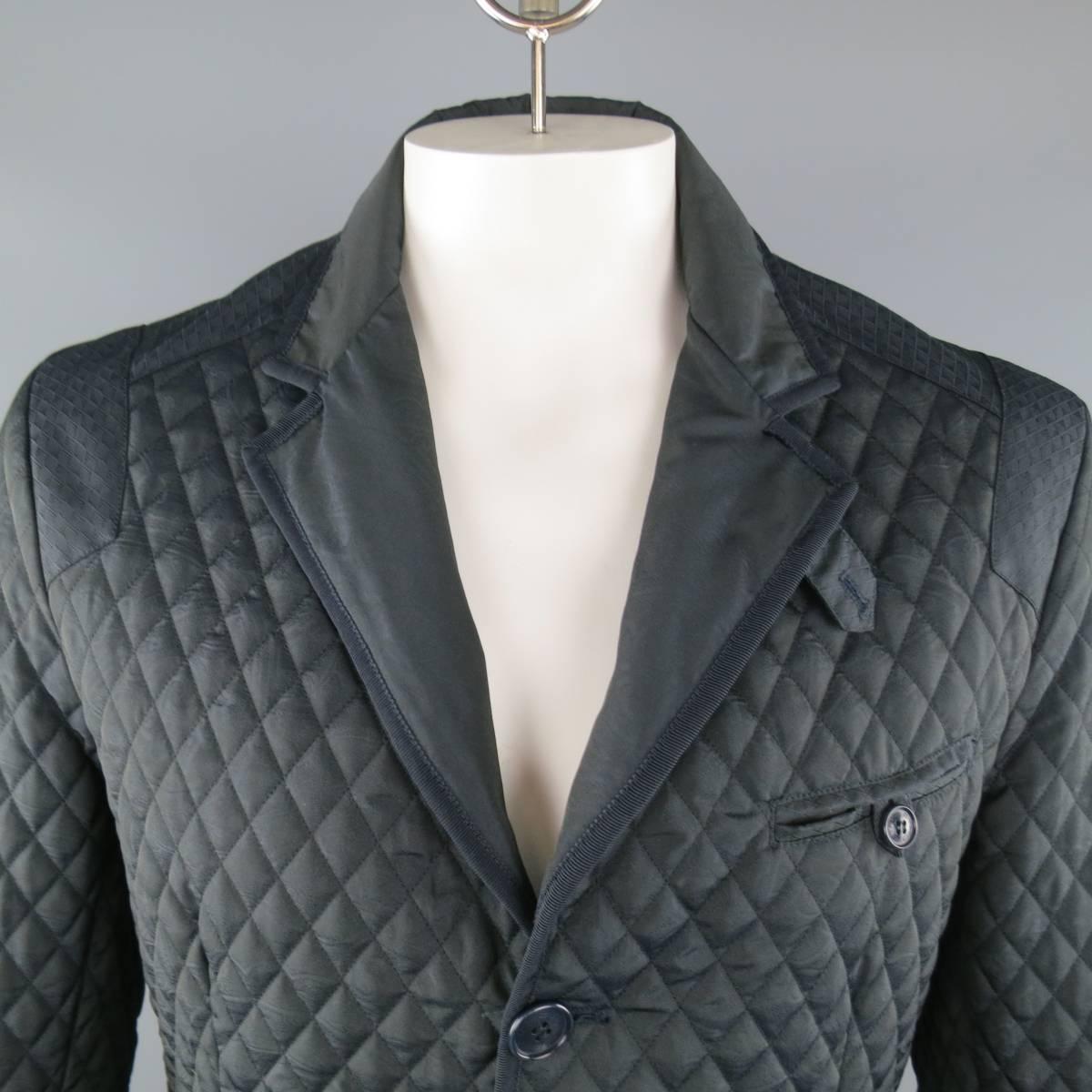 ETRO sport coat style jacket comes in a deep midnight navy blue quilted nylon with subtle paisley print and features a notch lapel, diamond pattern shoulder panels, faille piping, flap patch pockets, and paisley silk lining. Made in Italy.
