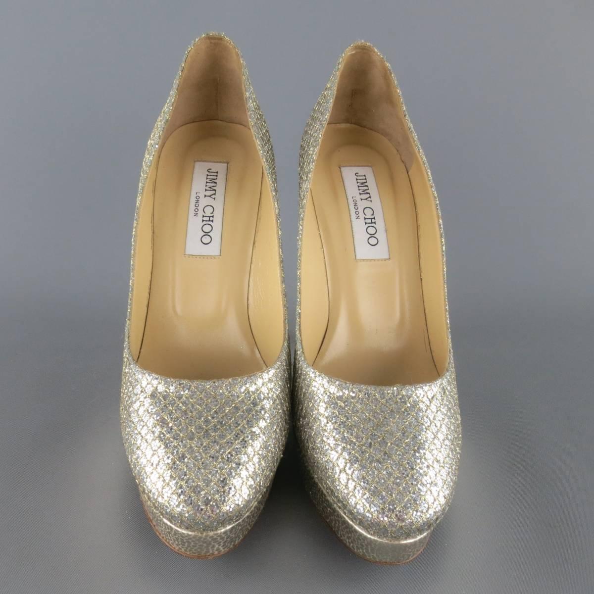 JIMMY CHOO pumps come in a silver glitter encrusted leather with mesh overlay and feature a rounded point toe with metallic silver textured leather platform, covered stiletto heel, and rhinestone 