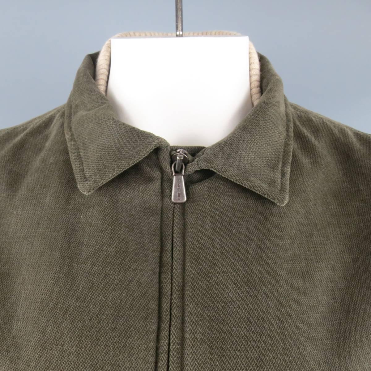 LORO PIANA Storm System vest comes in a soft olive green cotton fabric and features a double zip closure, zip pockets, chest slit pockets, plaid lining, and pointed collar with khaki ribbed knit baseball collar, embroidered logo suede back and