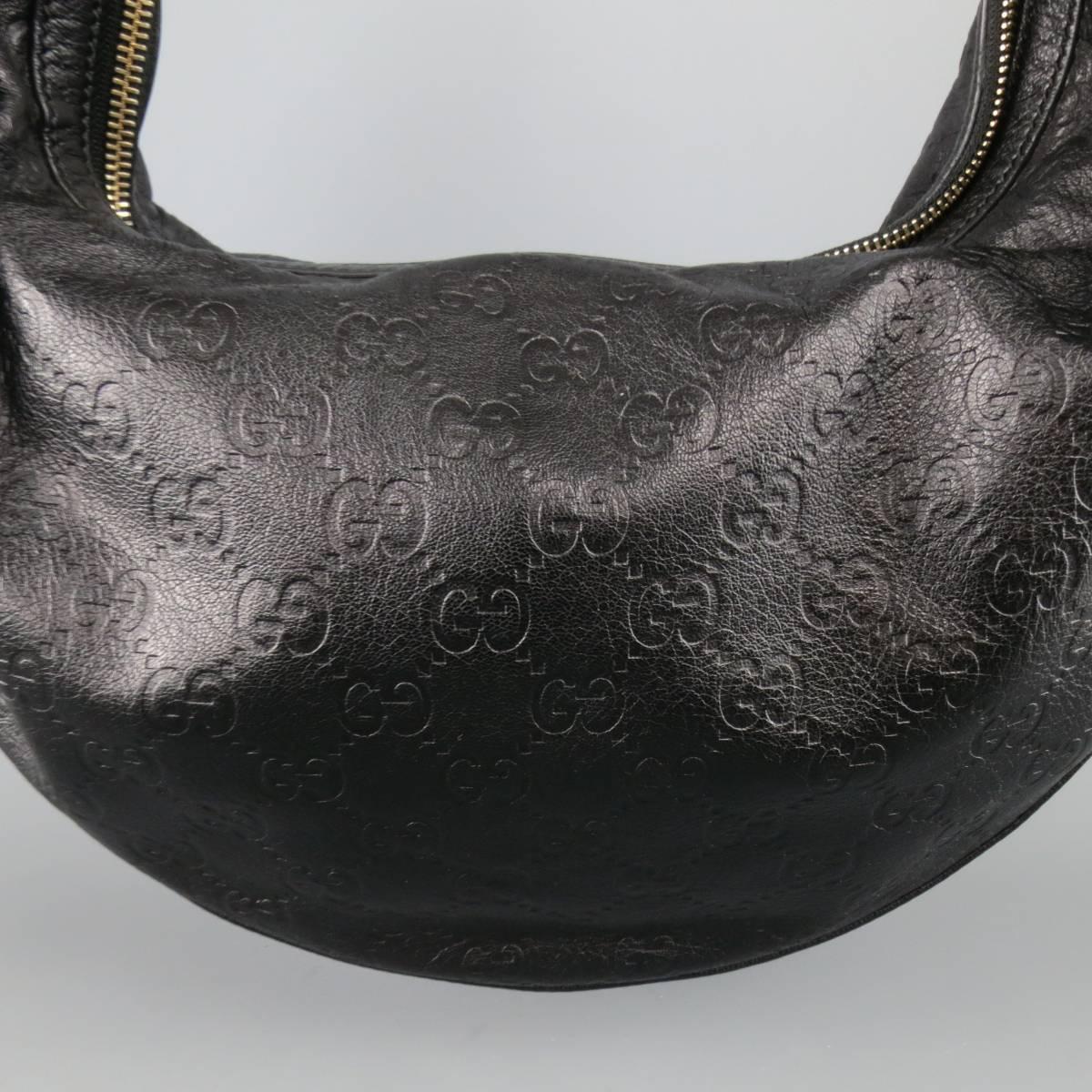 GUCCI hobo bag comes in smooth black Guccisima monogram embossed leather and features a half moon shape, top zip closure, leather handle with oversized light gold tone bamboo hoops, and printed canvas liner. Made in Italy.
 
Excellent Pre-Owned