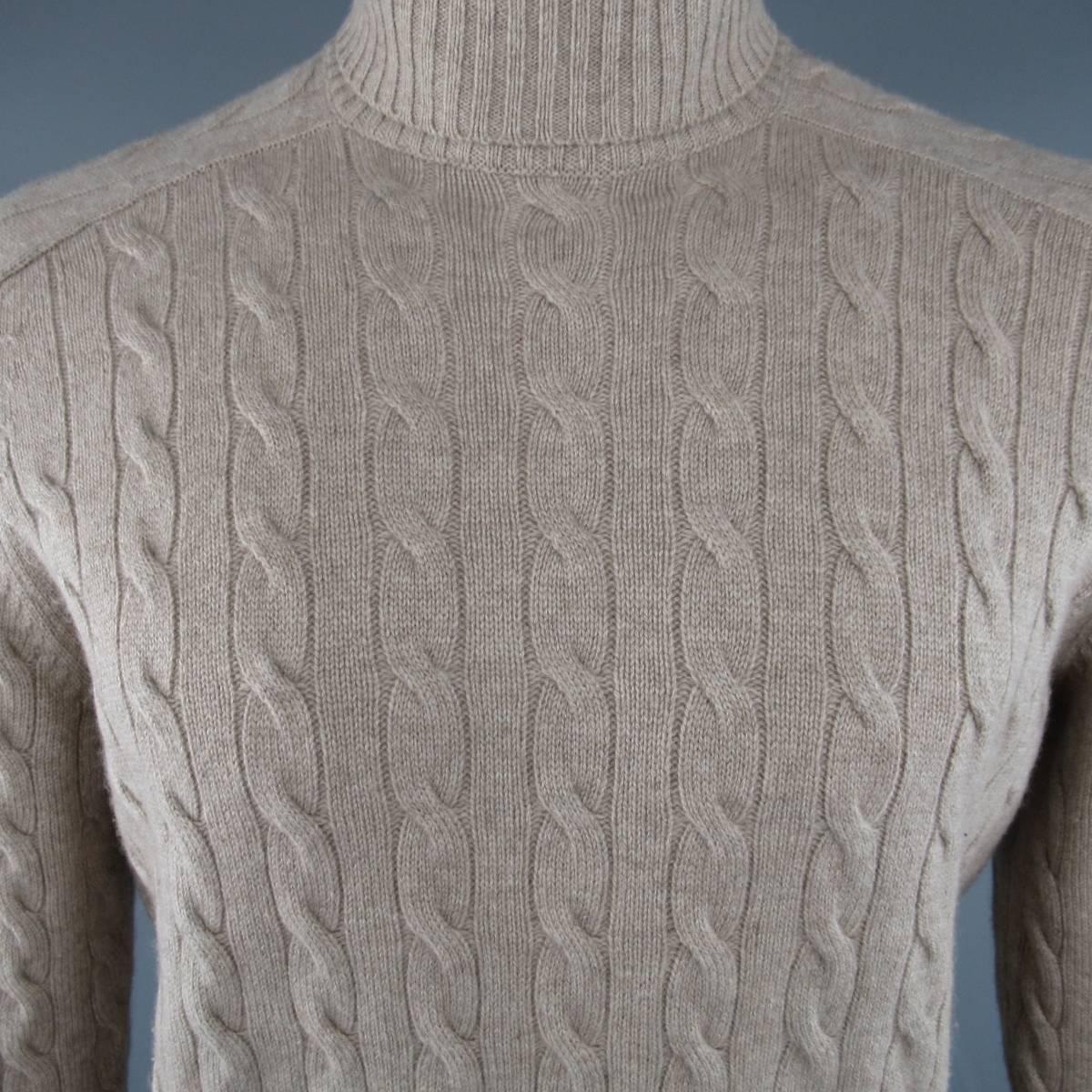 BRUNELLO CUCINELLI Turtleneck Sweater consists of cashmere blend material in a oatmeal color tone. Designed with a rib high collar, raglan shoulders and cable knit pattern throughout body. Rib cuff and hem. Made in Italy.
 
Good Pre-Owned