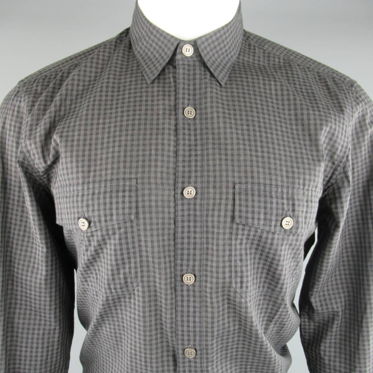 Fitted  GUCCI shirt comes in a charcoal gray and black gingham checkered plaid and features military style patch flap pockets, smoke silver tone buttons, and half hidden placket front. Made in Italy.
 
Excellent Pre-Owned Condition.
Marked: 39 /