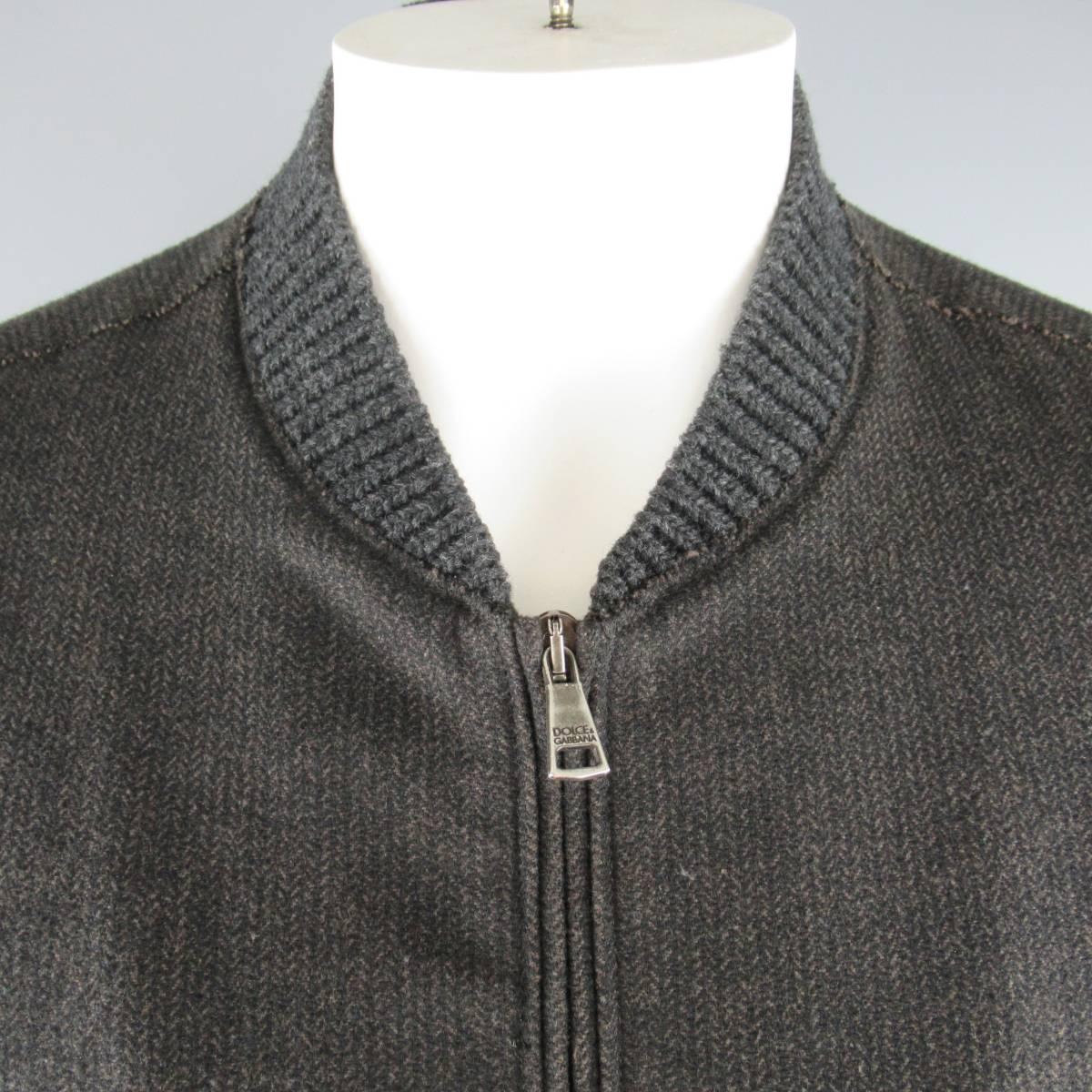 DOLCE & GABBANA bomber jacket comes in a charcoal and brown Herringbone wool blend flannel and features a knit ribbed baseball collar, slanted zip pockets, and raw edge details throughout. Made in Italy.
 
Good Pre-Owned Condition.
Marked: IT