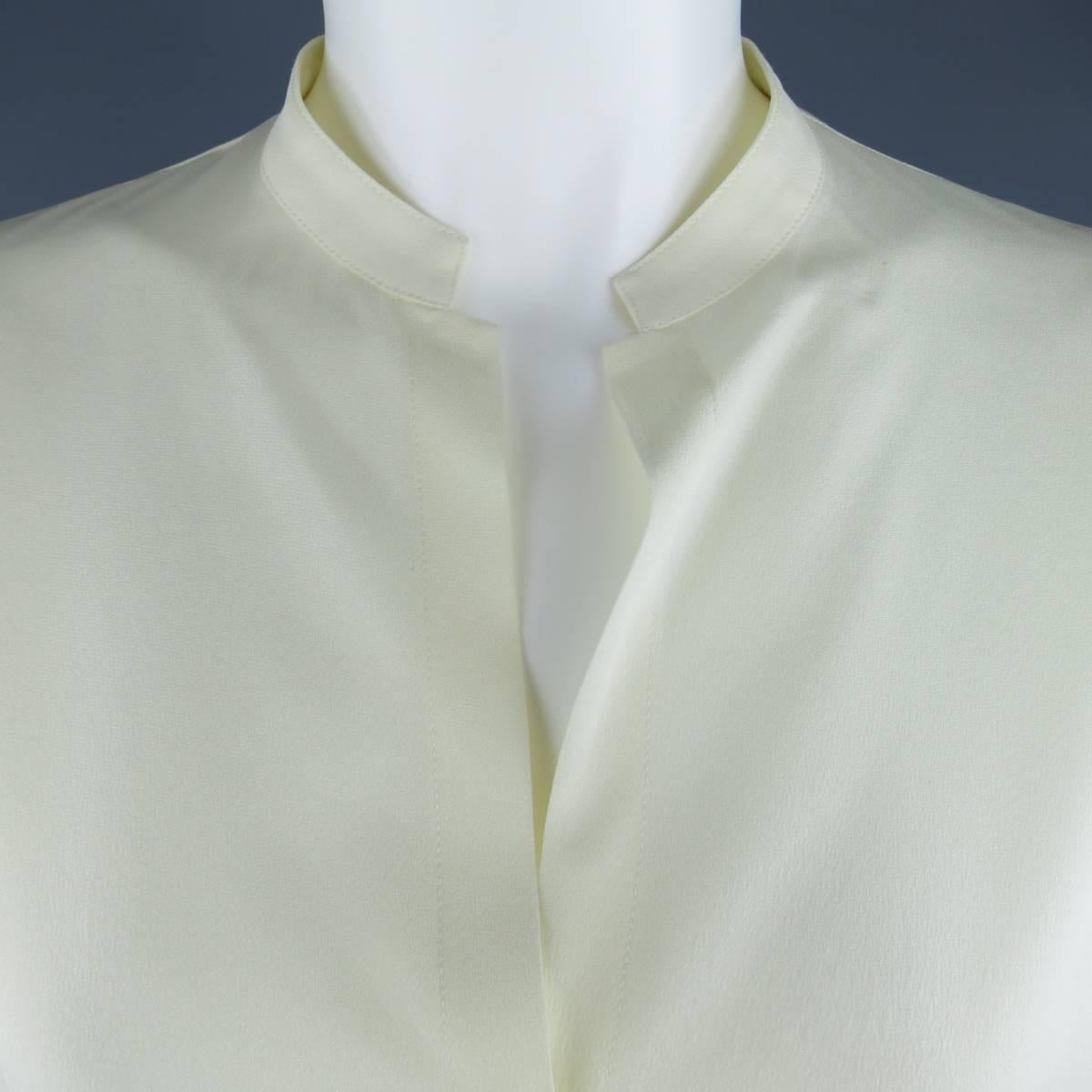 Vintage 1990's GIANNI VERSACE Couture blouse comes in a light weight cream silk crepe chiffon and features a band collar, v neckline, and long sleeves. Made in Italy.
 
Excellent Pre-Owned Condition.
Marked: IT 40
 
Measurements:
 
Shoulder: 19
