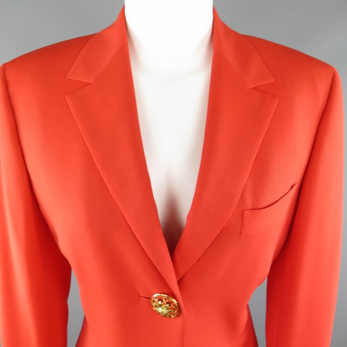 This fabulous vintage 1990's GIANNI VERSACE COUTURE blazer comes in a bold coral orange fabric and features a pointed notch lapel, three button closure with oversized, gold tone Medusa head statement jewelry button with orange enamel details and