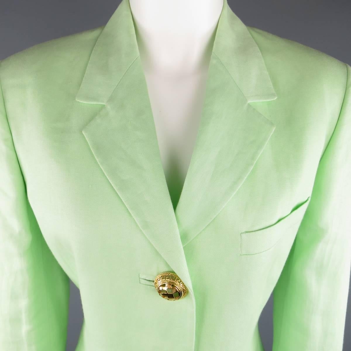 This fabulous vintage 1990's GIANNI VERSACE COUTURE blazer comes in a light weight mint green fabric and features a notch lapel and oversized gold tone Greek pattern cutout statement button closure. Care tag removed. Includes extra button. Made in