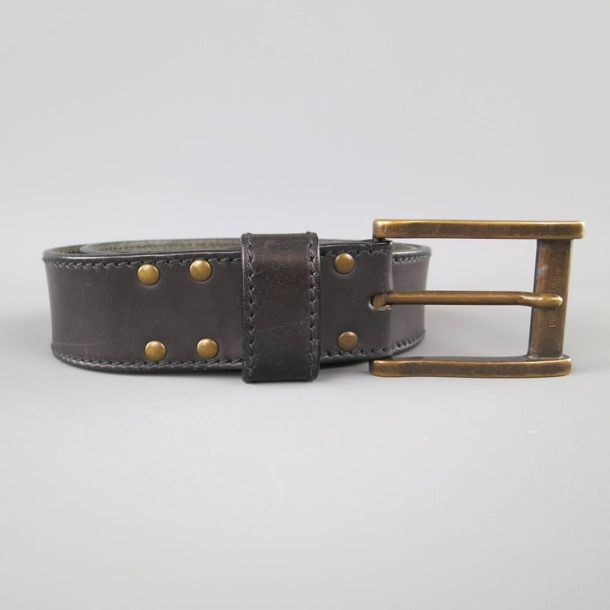 DIOR HOMME belt features a thick black leather strap with stitching and a large, dark gold tone brass buckle. Wear throughout. Made in Italy.
 
Good Pre-Owned Condition.
Marked: 85
 
Length: 36 in.
Width: 1.5 in.
Fits: 32-36 in.
Buckle: 2.75 x 2