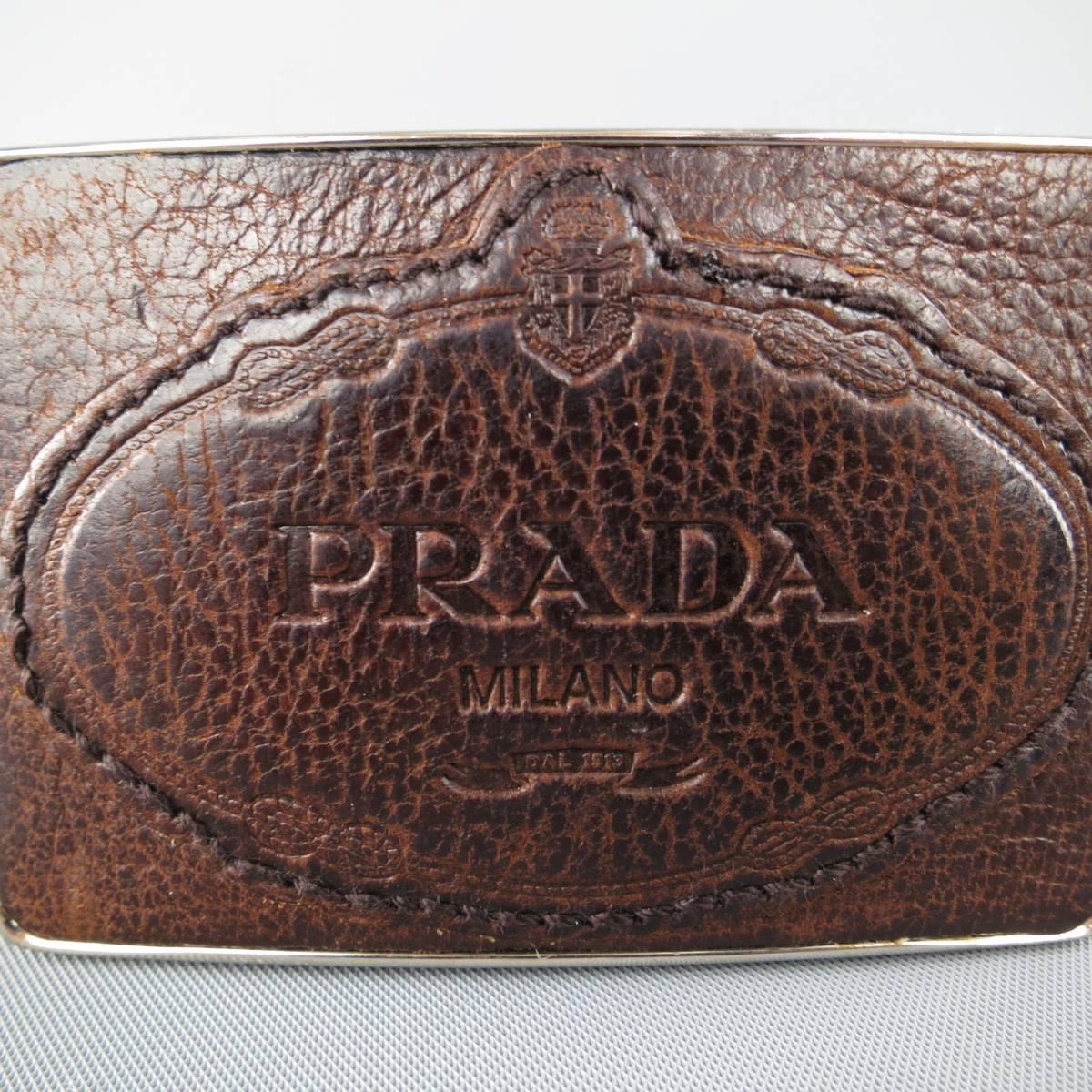 PRADA dress belt comes in a brown textured leather with a rectangular, logo embossed leather buckle on silver tone metal base. Minor wear. Made in Italy.
 
Good Pre-Owned Condition.
Marked: 95/38
 
Length: 42 in.
Width: 1.25 in.
Fits: 35-39