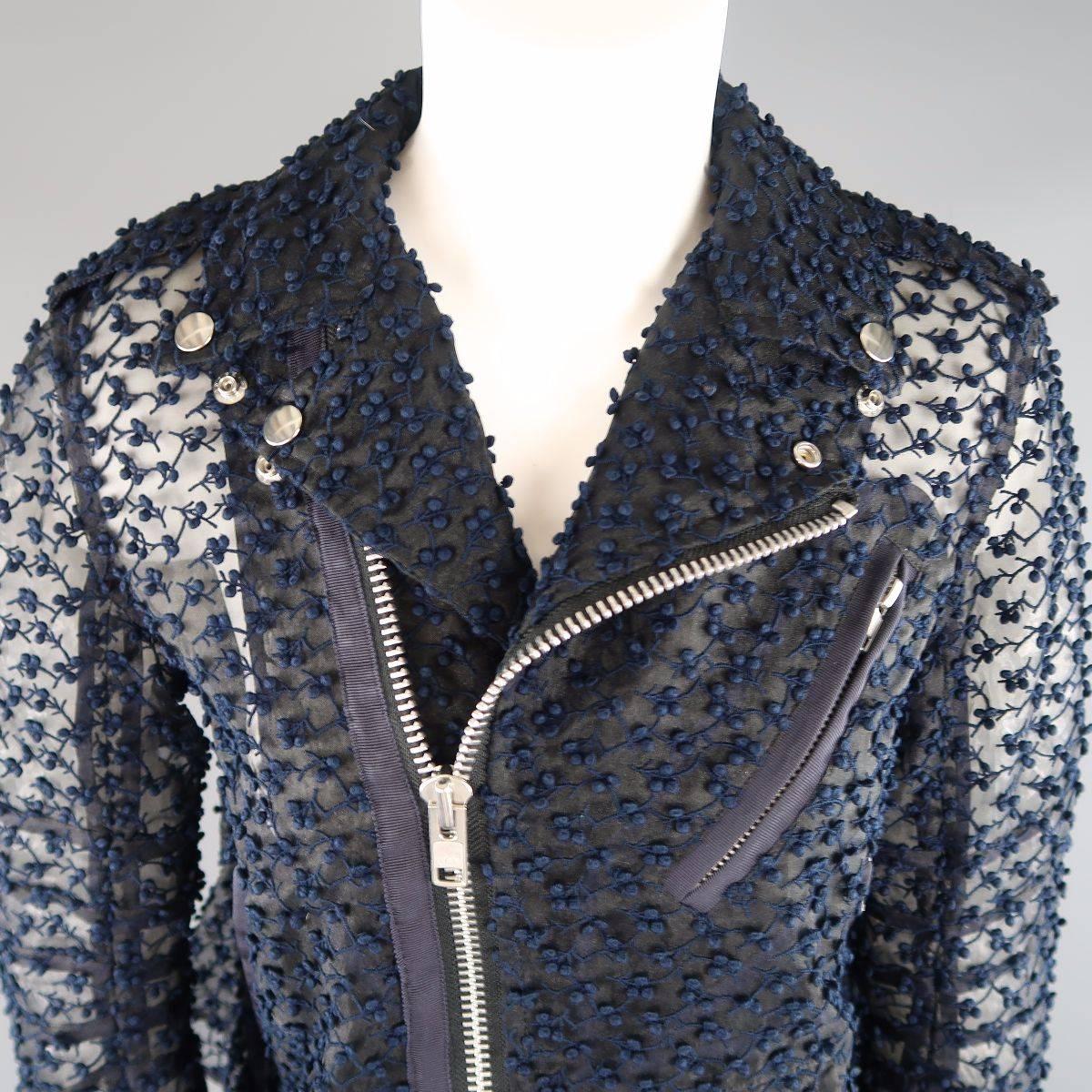 This gorgeous SACAI biker jacket comes in a textured, embroidered sheer navy blue tafeta material and features a pointed lapel with silver tone snaps, asymmetrical zip closure, faille piping, belted front, zip cuffs, and a ruffle pleated back. Made