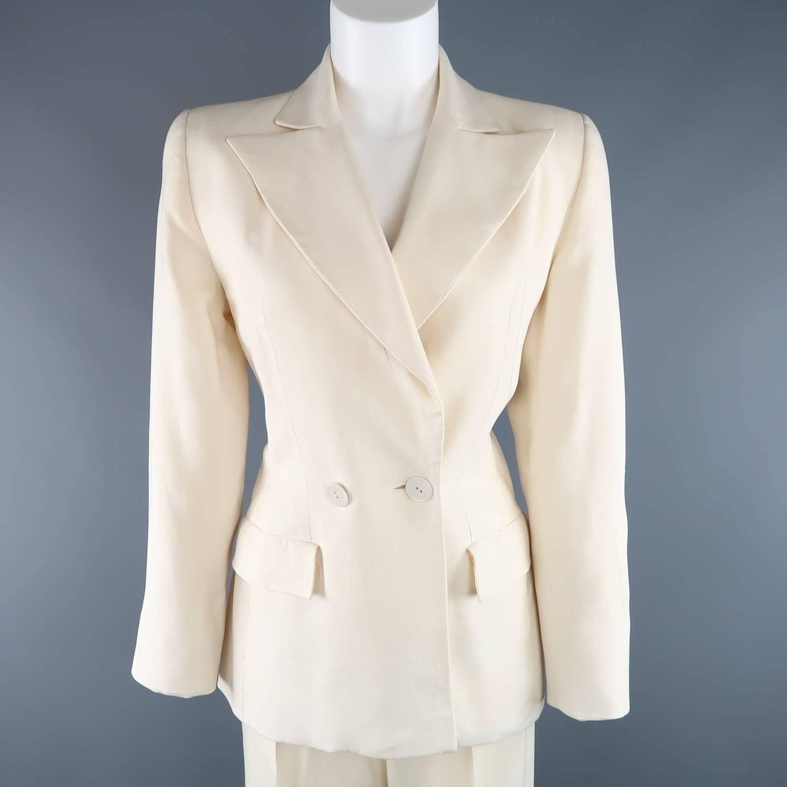 This gorgeous vintage YVES SAINT LAURENT Rive Gauche suit comes in textured cream silk and includes a peak lapel, double breasted blazer jacket and matching high rise, pleated trousers. Imperfections on trousers. As-Is. Made in France.
 
Good 