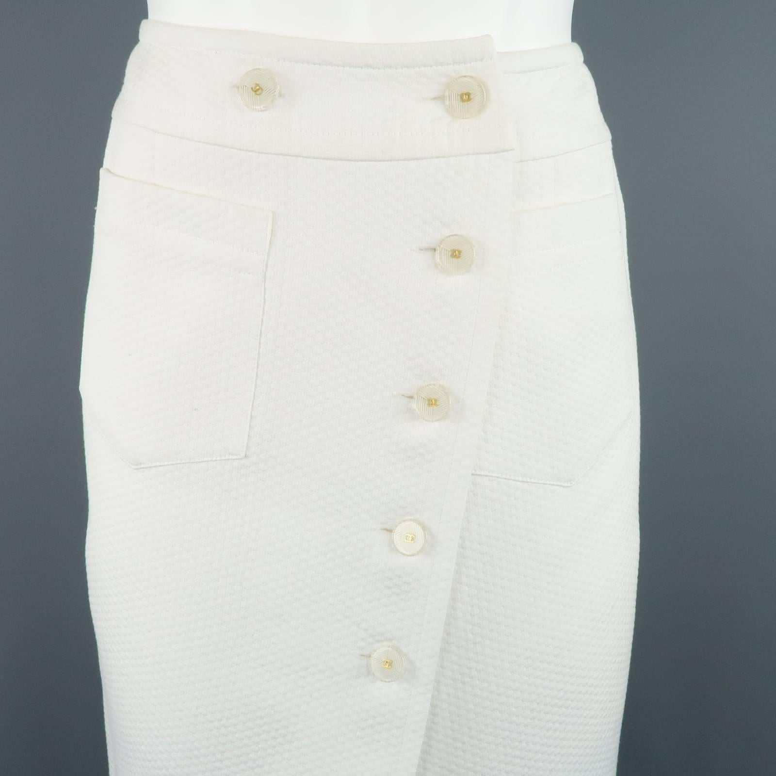 CHANEL A-line skirt comes in a white textured cotton fabric and features an asymmetrical wrap button closure with clear & gold tone CC buttons, patch pockets, and back slit. minor wear throughout. Made in France.
 
Good  Pre- Owned