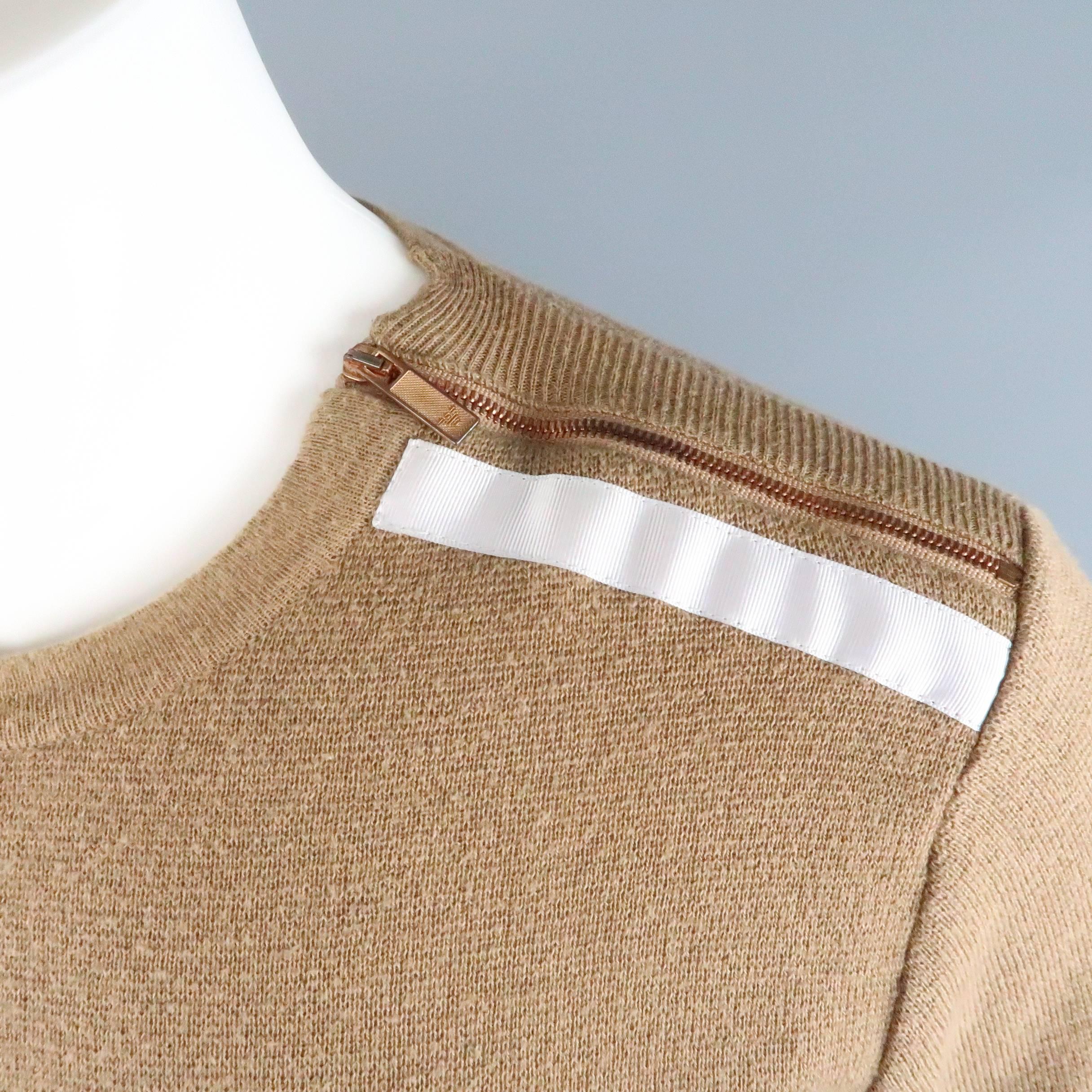 EMPORIO ARMANI pullover sweater comes in tan camel wool cotton blend knit and features a crewneck with silver stripe detailed, bronze tone zip shouder, embroidered logo hem, and layered sight gray layered cuffs. Discoloration on zipper. As-Is.

