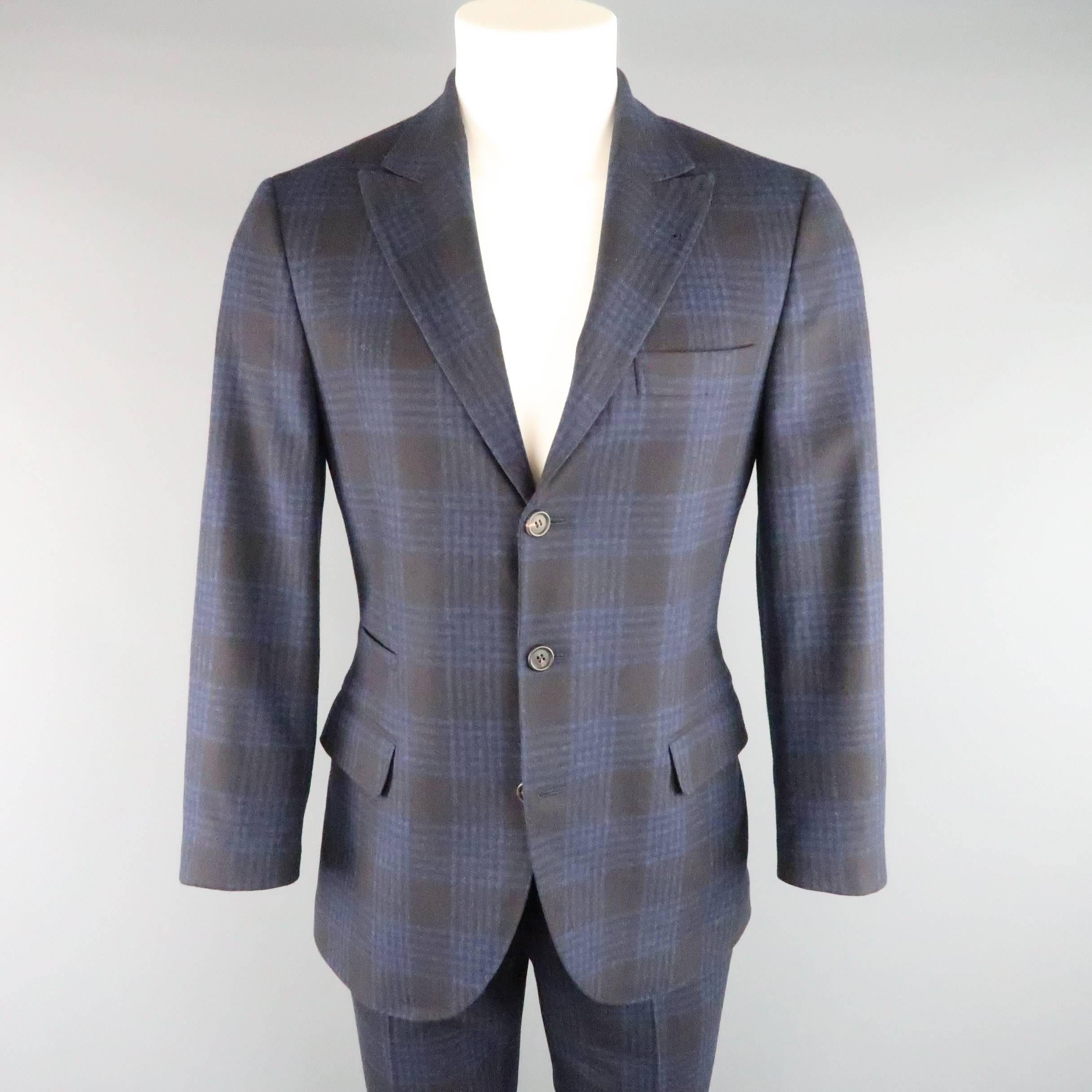 Two piece BRUNELLO CUCINELLI suit comes in navy and black plaid wool cashmere silk blend flannel and includes a single breasted, peak lapel, three button sport coat and matching cuffed, flat front trousers. Made in Italy.

Retails at: