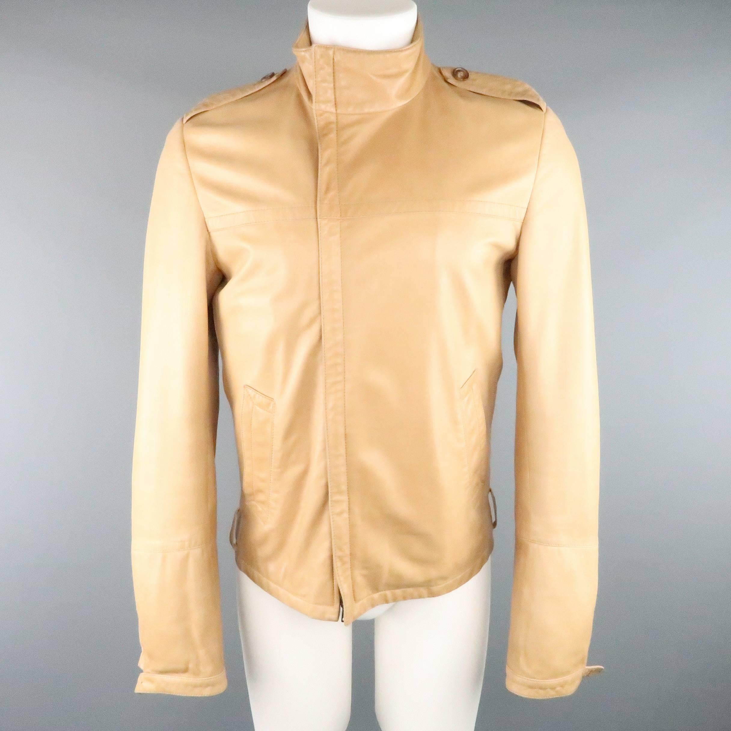 This GUCCI by TOM FORD circa 2000 jacket comes in a butter soft light tan leather and features an asymmetrical zip high collar, epaulets, slanted pockets, and tab cuff sleeves. Minor wear and missing belt and cuff hardware. As-Is. Made in Italy.
