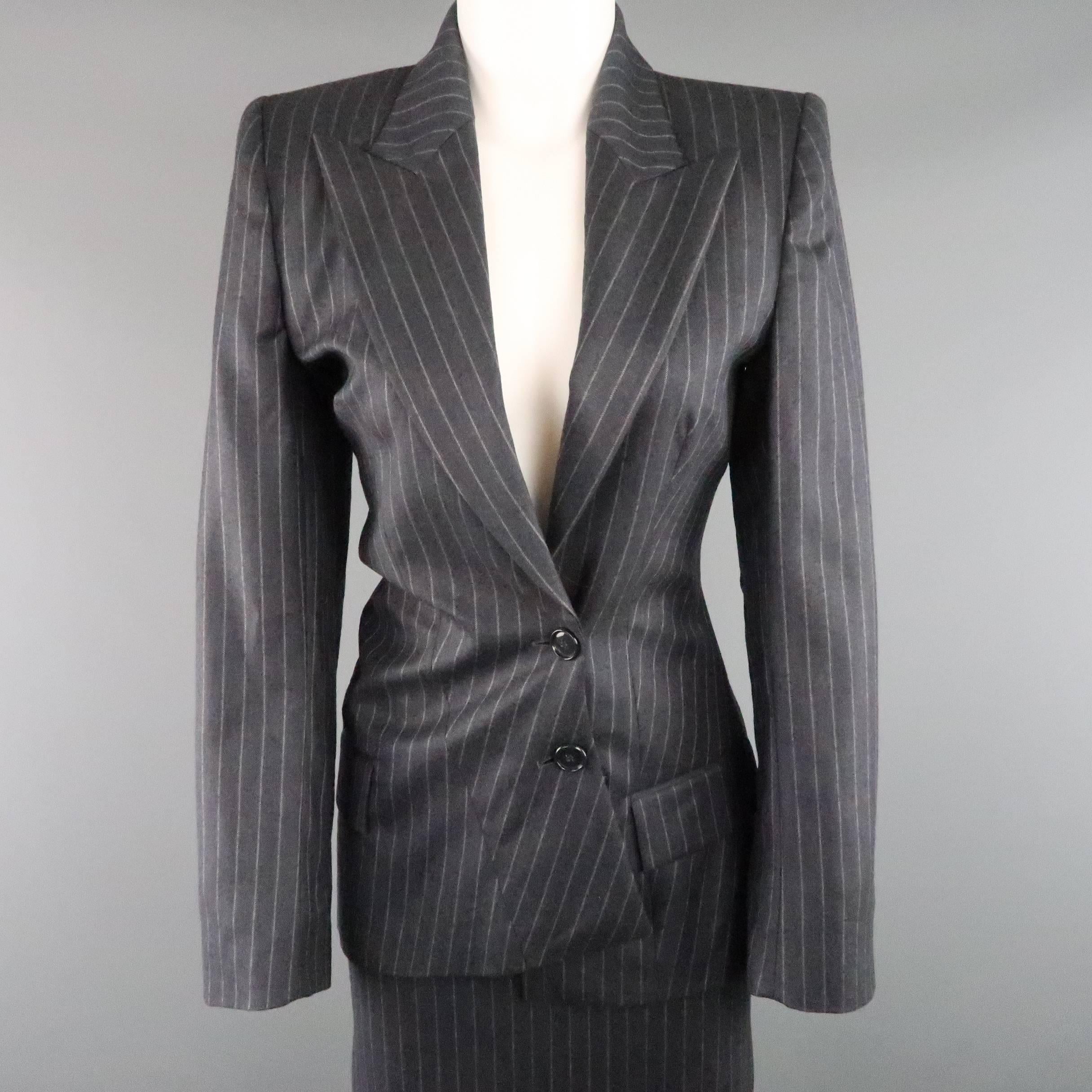 This fabulous early 1990's skirt suit by rare label COPPERWHEAT BLUNDELL comes in a classic gray pinstripe wool twill and includes a peak lapel blazer with asymmetrical button closure and matching pencil skirt. Runs small, see measurements. Made in