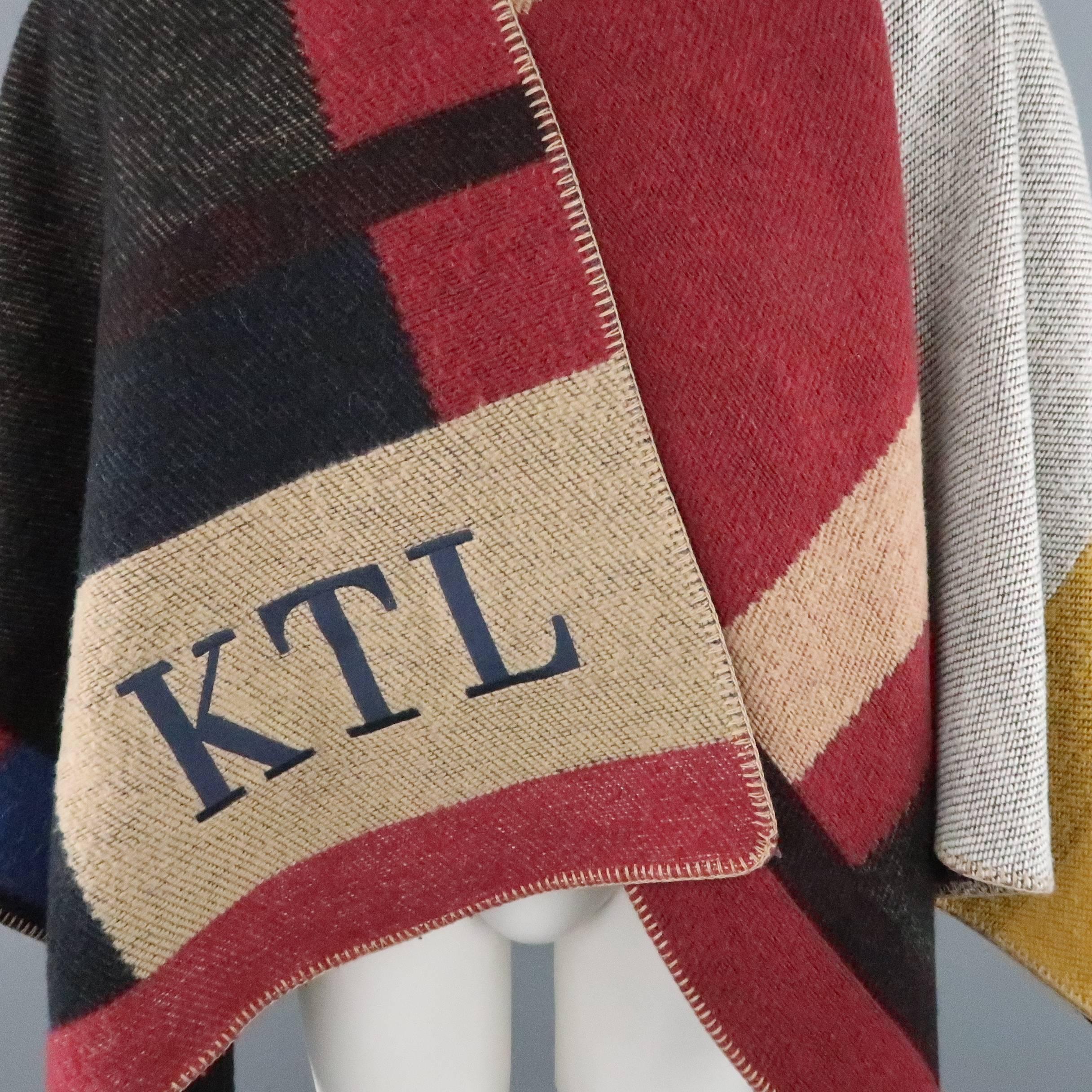 BURBERRY PRORSUM Fall 2014 runway poncho comes in a large scale, multi color interpretation of the houses signature plaid in a wool cashmere blanket knit, open front poncho. Monogrammed with 