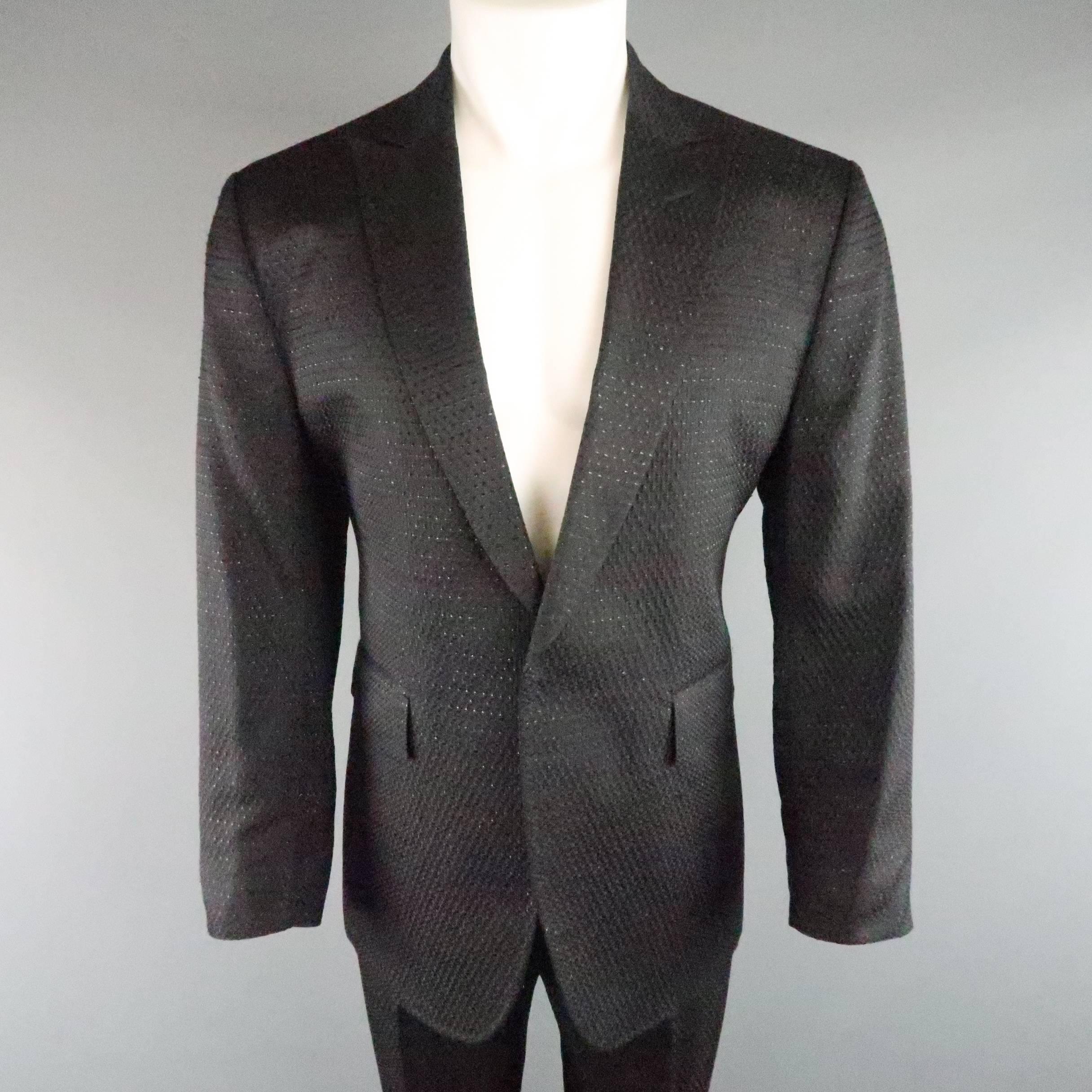 CoSTUME NATIONAL statement suit comes in a black brocade textured fabric with black sparkle foil throughout and includes a single breasted sport coat with peak lapel, hidden single button closure, and single button cuffs and matching flat front