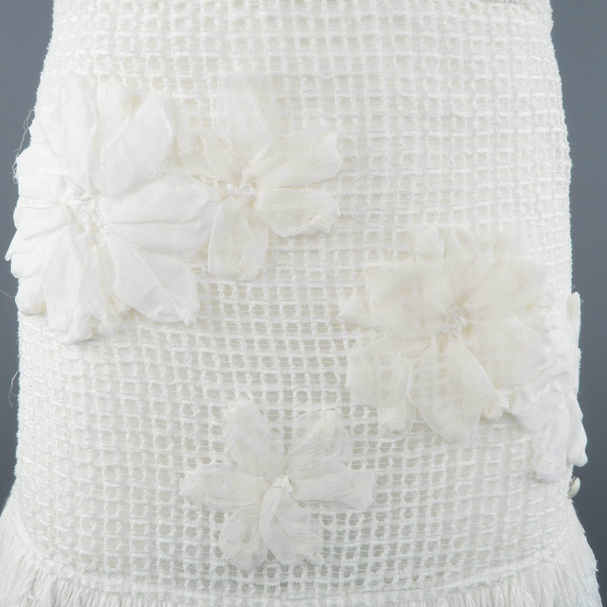 CHANEL mini skirt comes in a white mesh boucle knit and features a textured waistband, fringe knit hemline, chiffon flower appliques, and satin liner. Made in Italy.
 
Excellent Pre-Owned Condition.
Marked: FR 36
 
Measurements:
 
Waist: 30 in.
Hip: